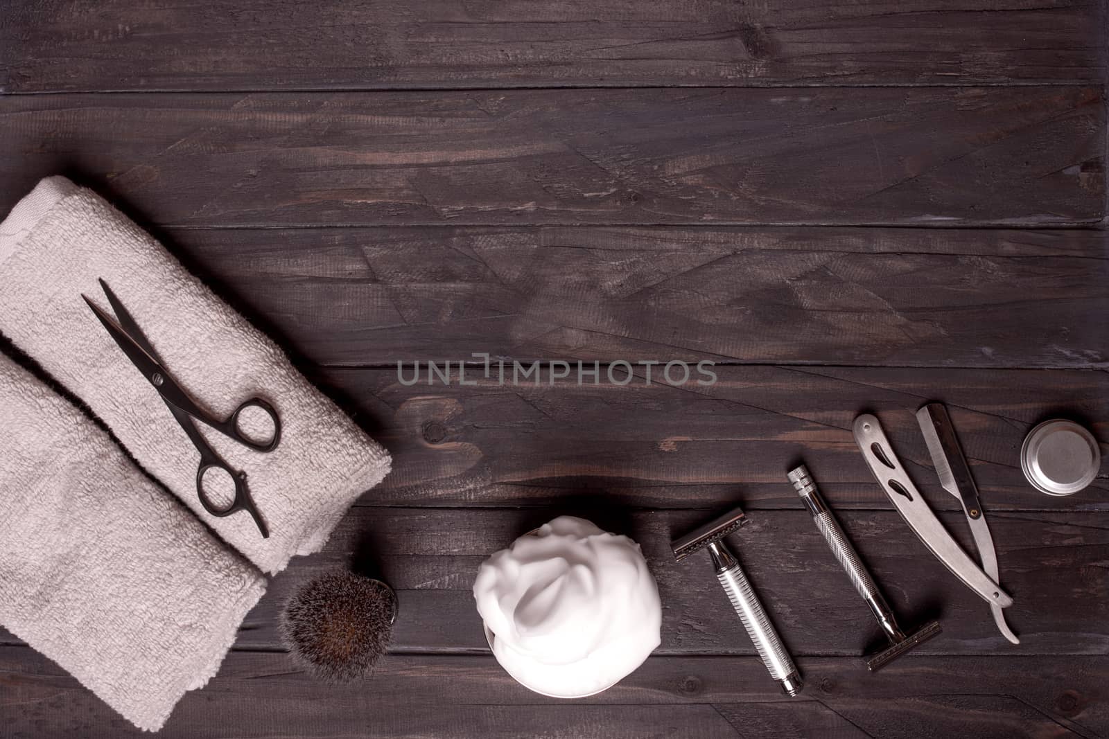 Razors, brush, balsam, perfume, towels and scissors on wood background. by Iryna_Melnyk