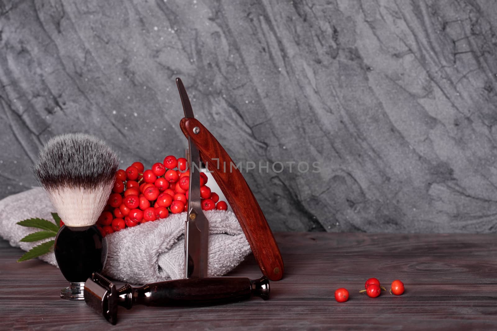 Razors, brush, towels and rowan on wood background by Iryna_Melnyk