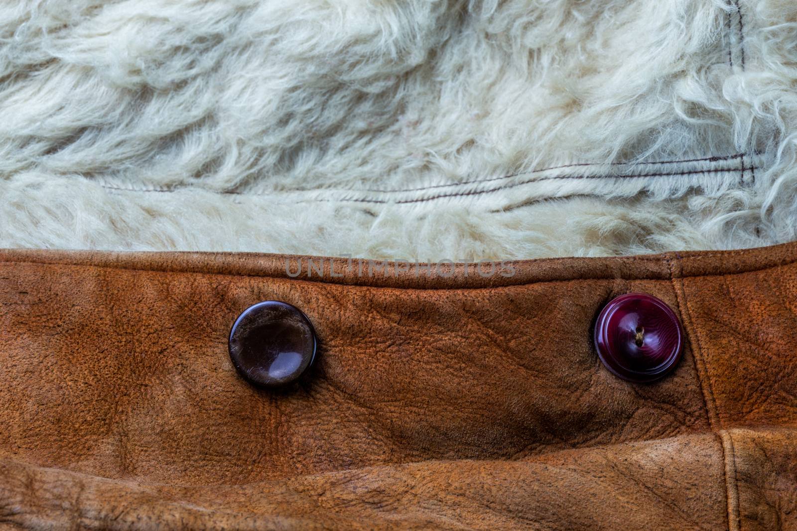 small brown thick seude jacket with white sheep fur lining closeup texture and background with selective focus and blur