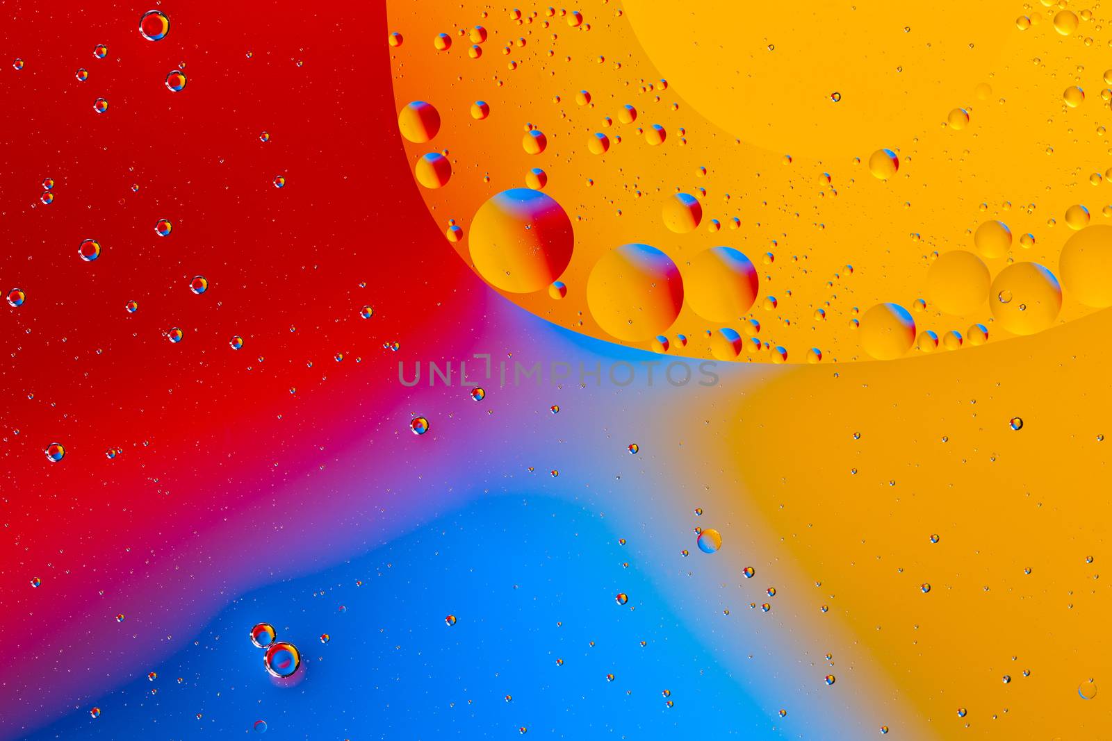 Oil on water flat colorful macro abstract background photographic image. Red, yellow and blue color,