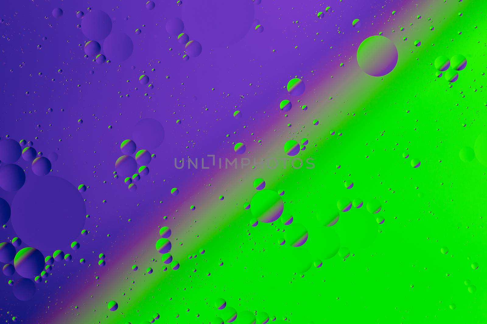 Oil on water flat colorful duotone macro abstract background photographic image. Violet-green diagonal split line.