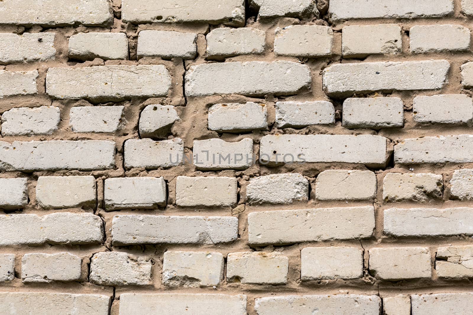 Deep cracked white silicate brick wall closeup texture and background. Horizontal shot.