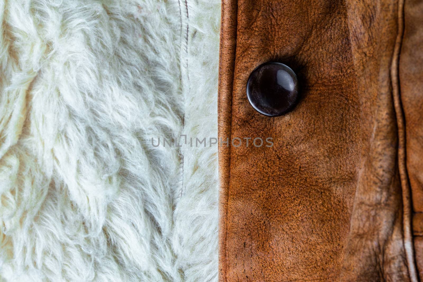 small brown thick seude jacket with white sheep fur lining closeup texture and background with selective focus and blur