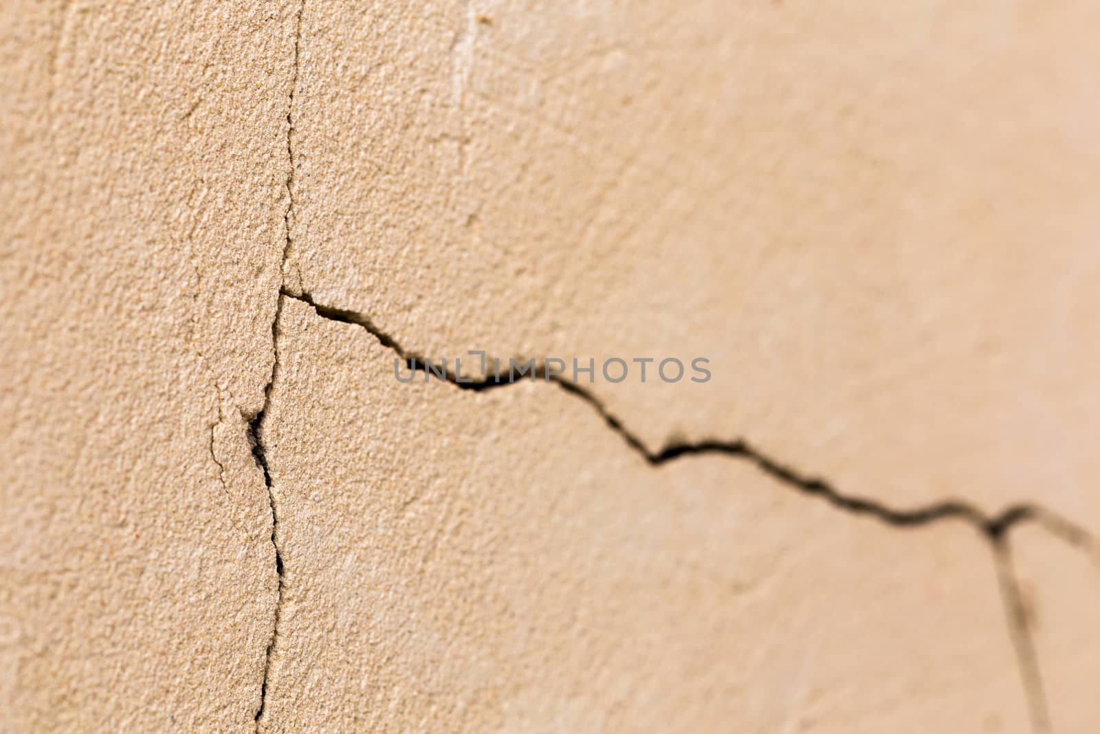 closeup background of cracked light porple plaster wall with selective focus and naturla blur.