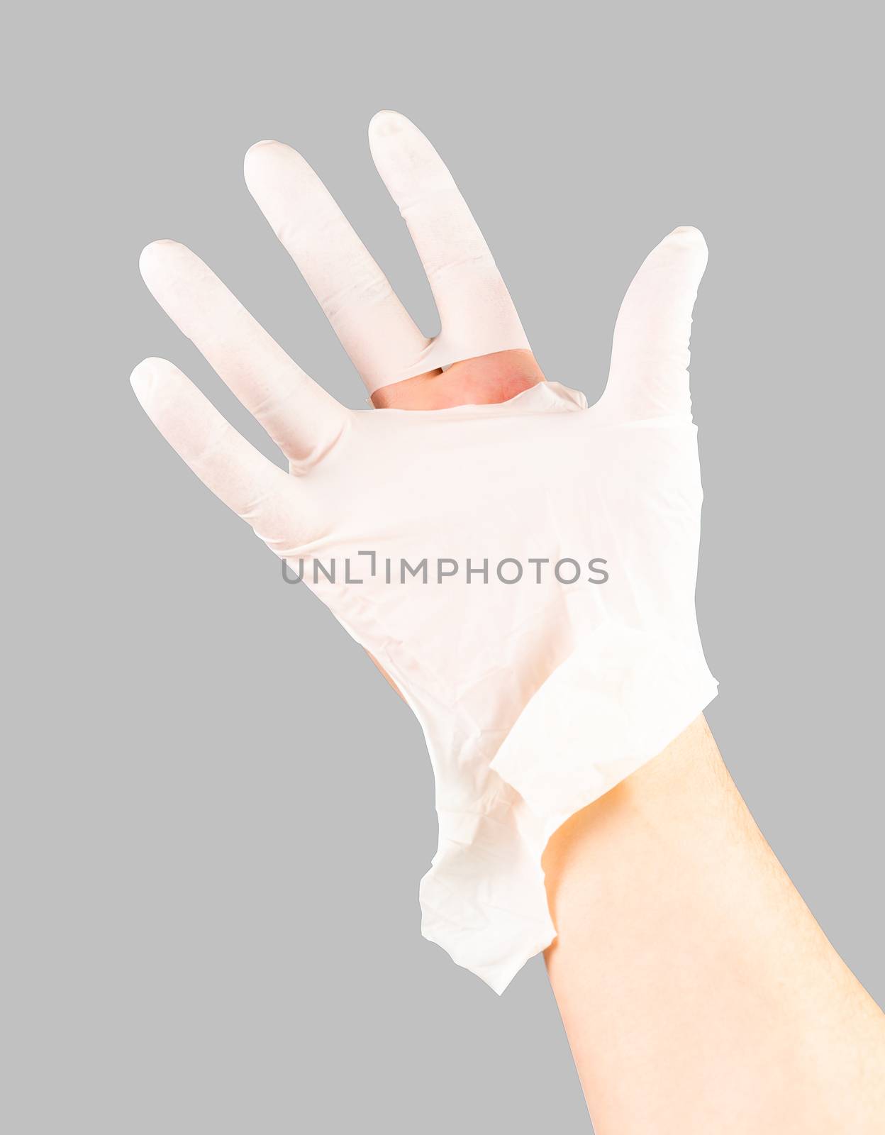 broken white latex surgeon medical glove on caucasian hand isolated on graybackground.