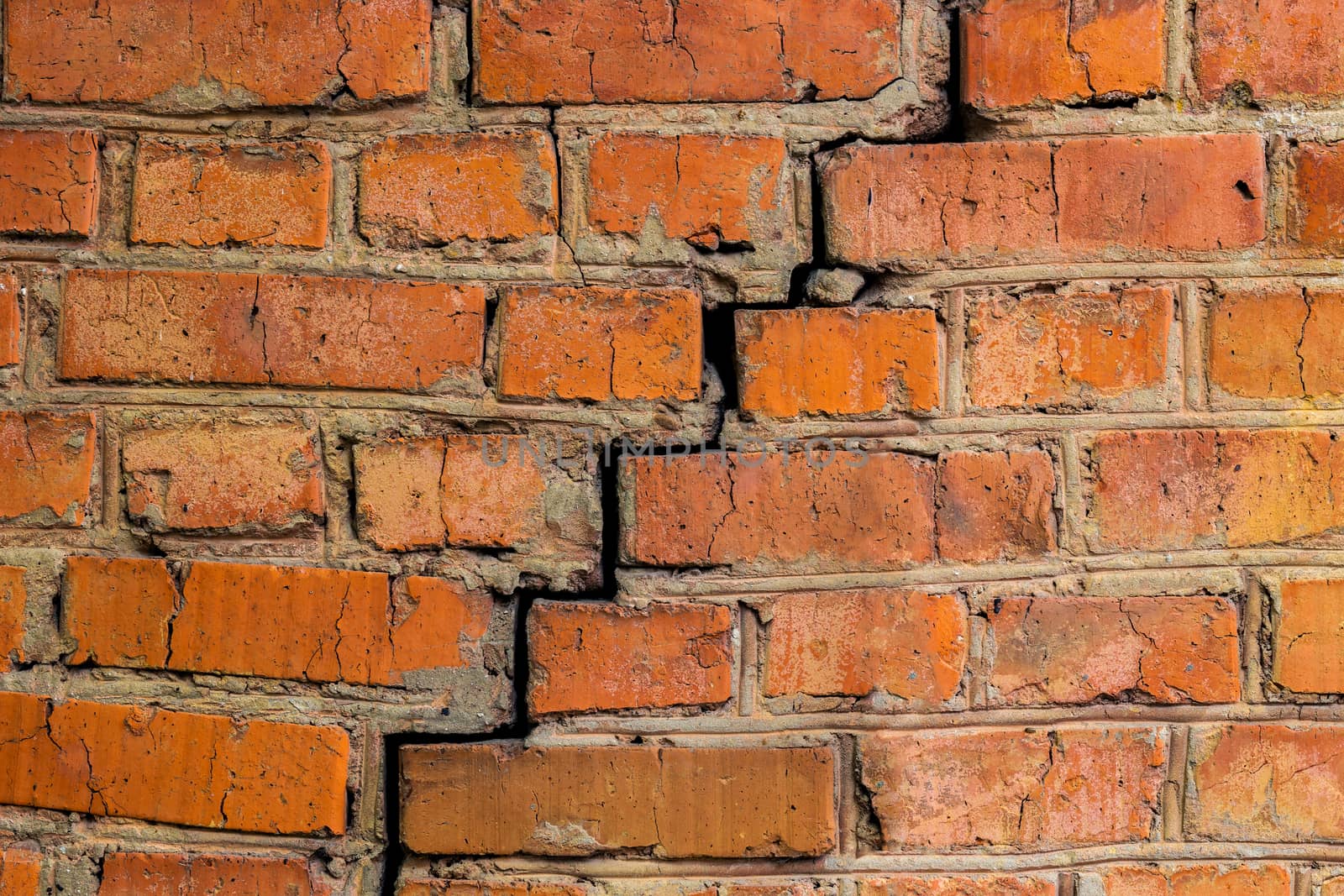 deep cracked orange brick wall closeup texture.