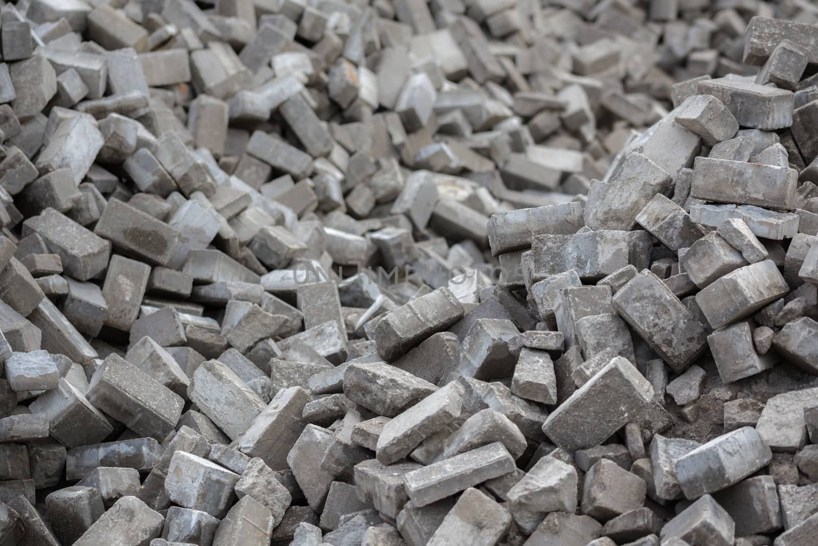 Pile of dismounted gray modern urban pavement bricks with selective focus. Result of russian government corruption in city infrastructure renovation.