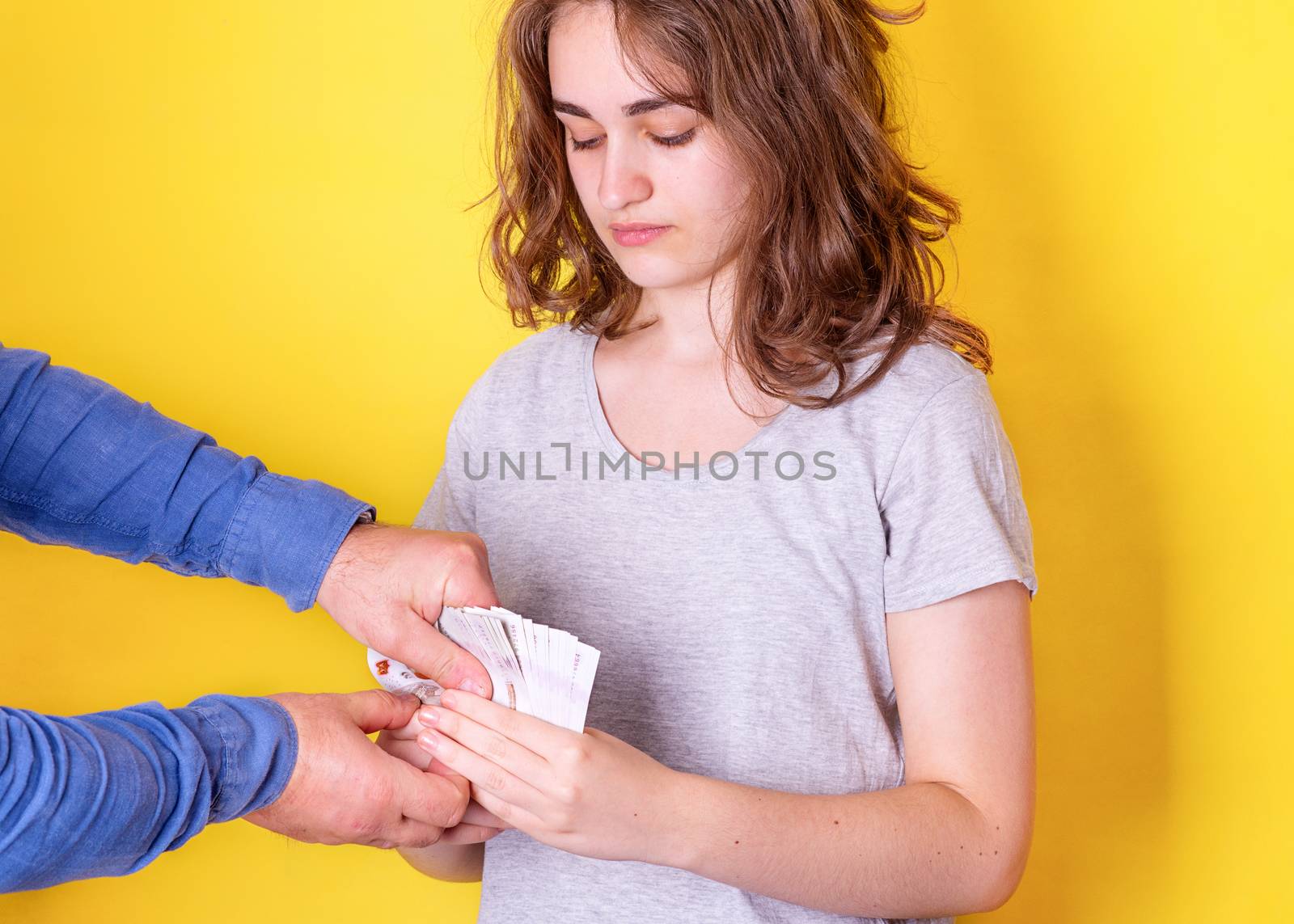 Unhappy young woman holding money and man taking away money. The payment holiday came to end.