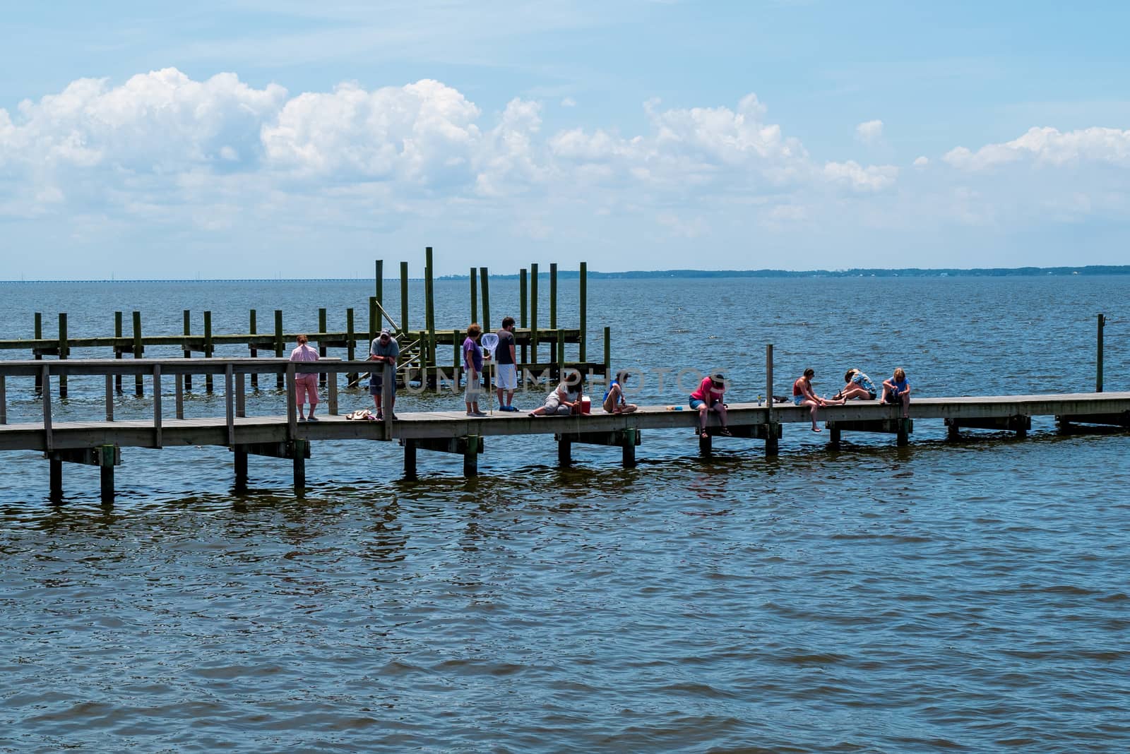 Duck, North Carolina, USA -- June 9, 2020.  Photo of people fishing and crabbing from a pier in Duck, NC.