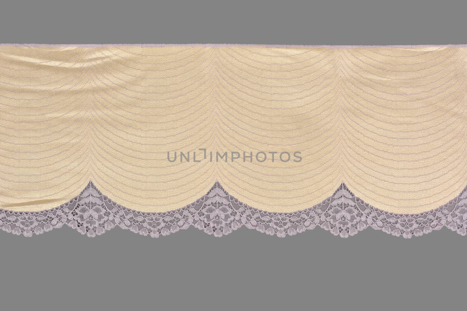 beige pink color straight strip of lace fabric on gray background. Elastic silk nylon braid border. use clothes linen decoration. repeating pattern and interweaving threads. texture for websites