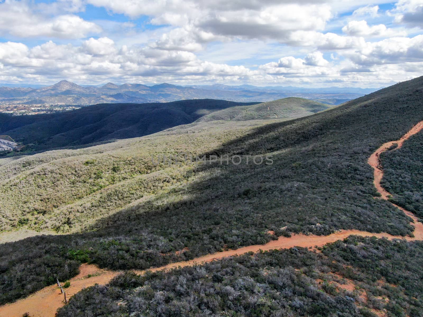 Aerial view of Black Mountain in Carmel Valley, San Diego, California, USA. Green dry mountain during sunny cloudy day with hiking trails, perfect for sport activity an leisure time..