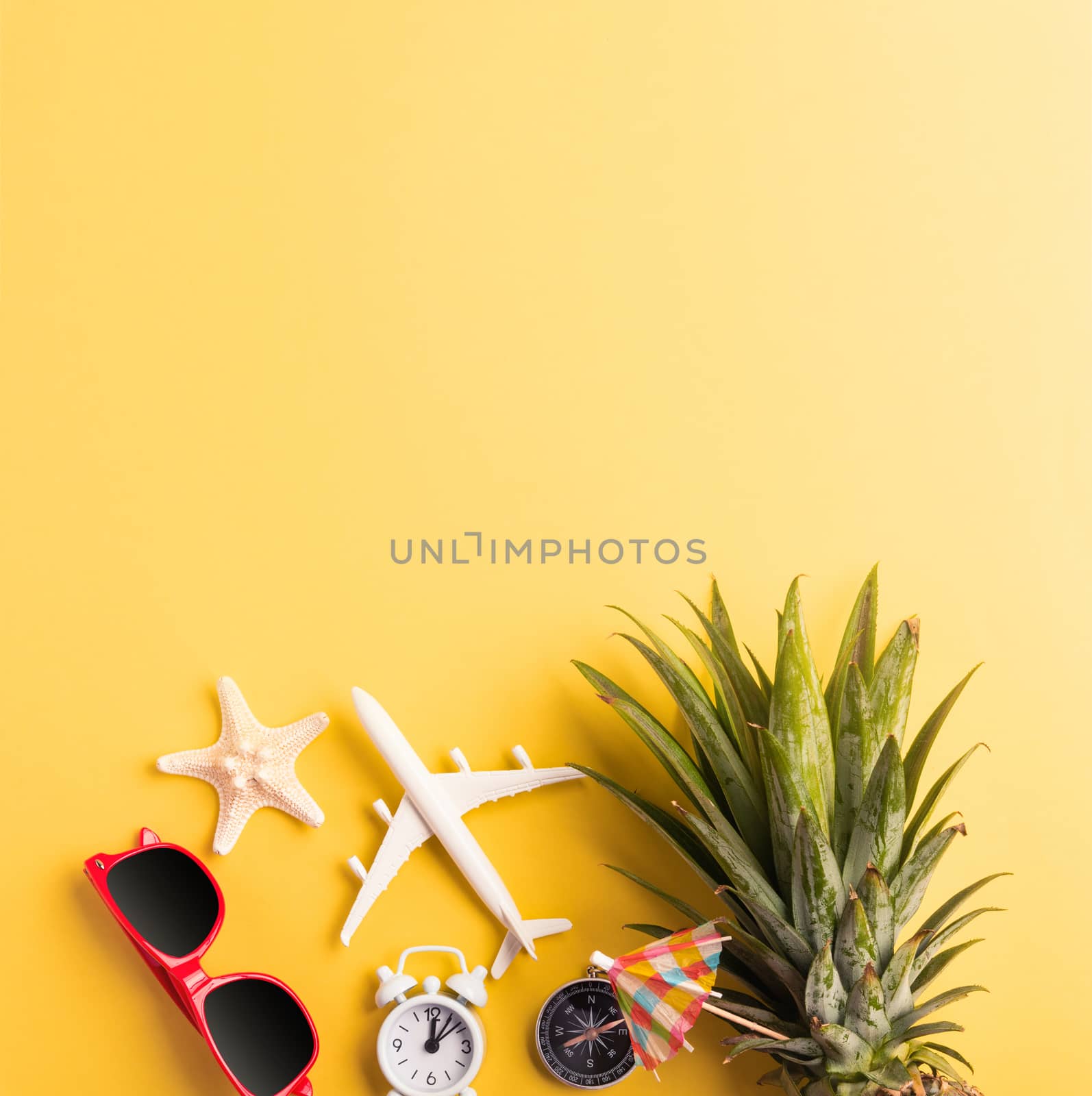 Celebrate Summer Pineapple Day Concept, Top view flat lay of funny pineapple, sunglasses, model plane, starfish and clock alarm isolated on yellow background, Holiday summertime in tropical