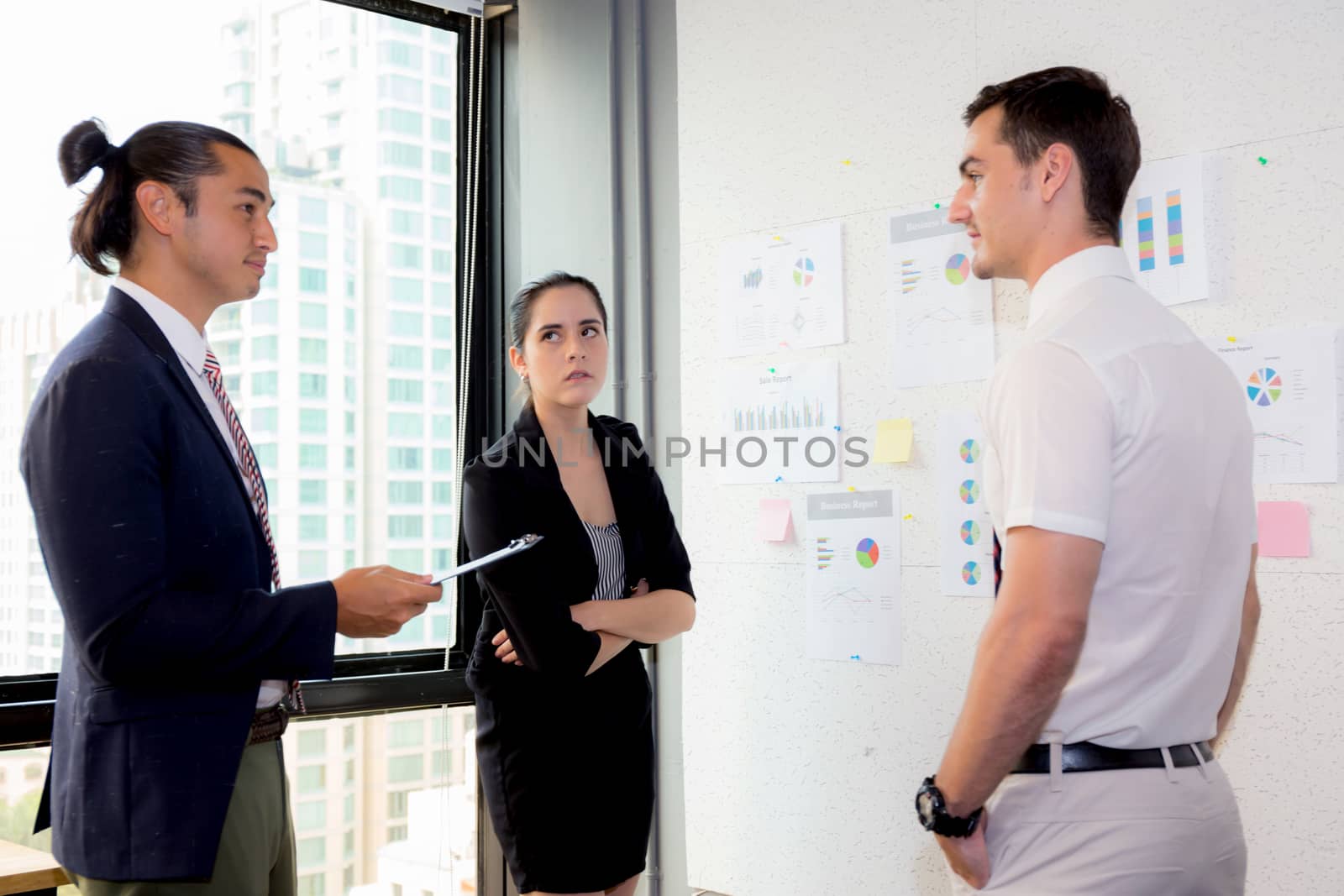three business people in modern office looking report and analyzing with talking in meeting room.