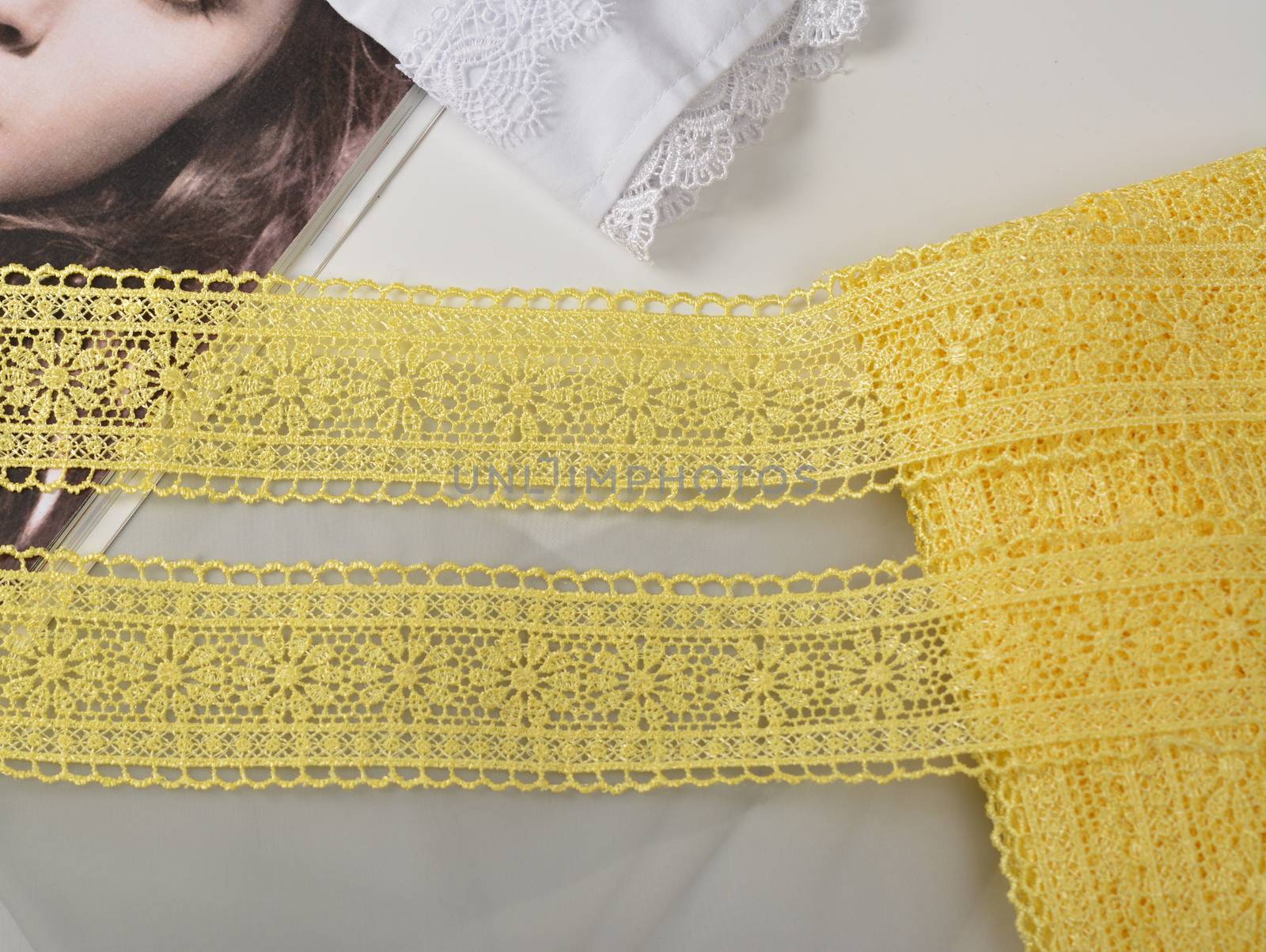Tapes of yellow gentle guipure, beauty lace fabric. Elastic material. Using for Atelier and needlework store. Space for text. repeating pattern and interweaving threads. texture for websites