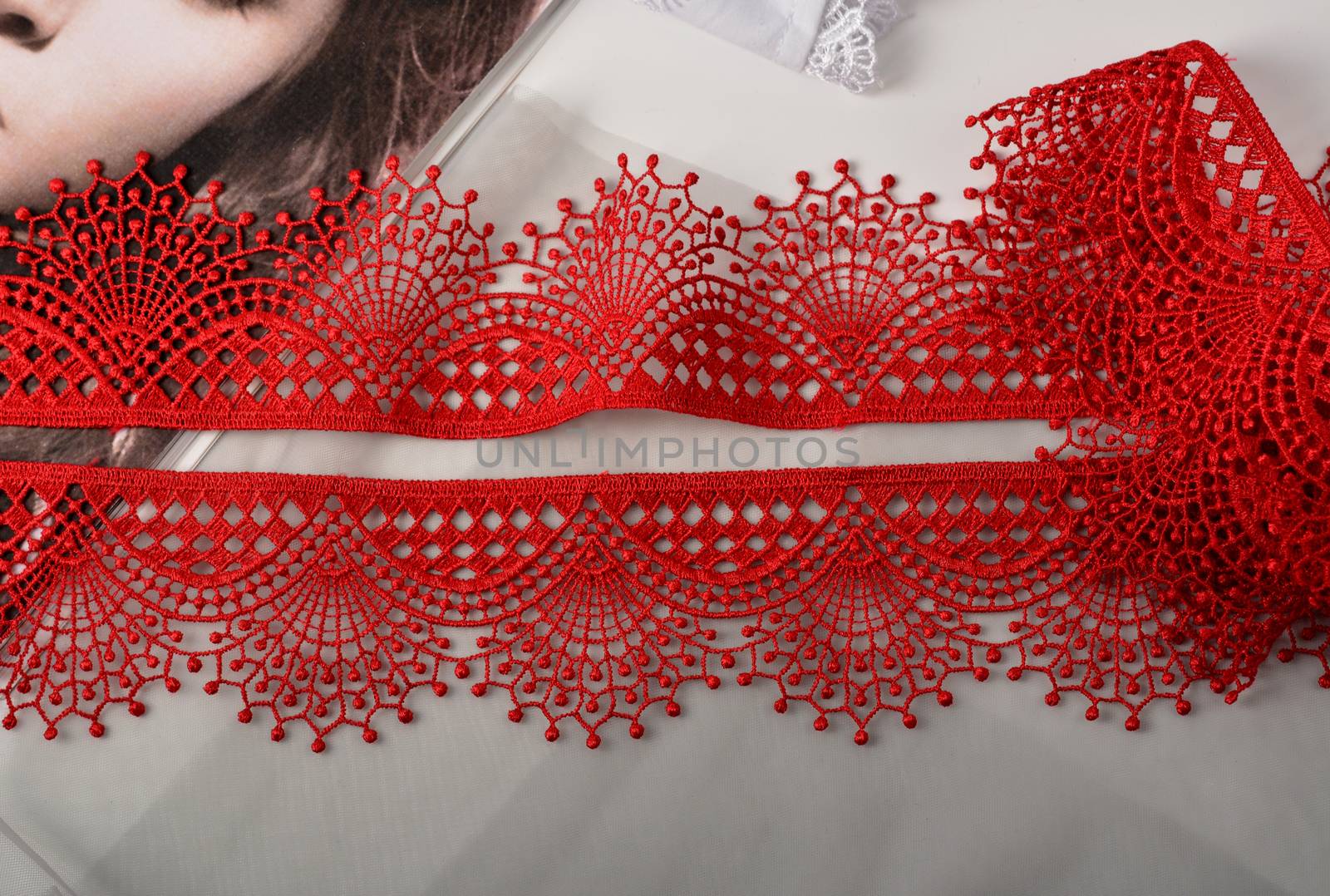 Tapes of red gentle guipure, beauty lace fabric. Elastic material. Using for Atelier and needlework store. Space for text. repeating pattern and interweaving threads. texture for websites