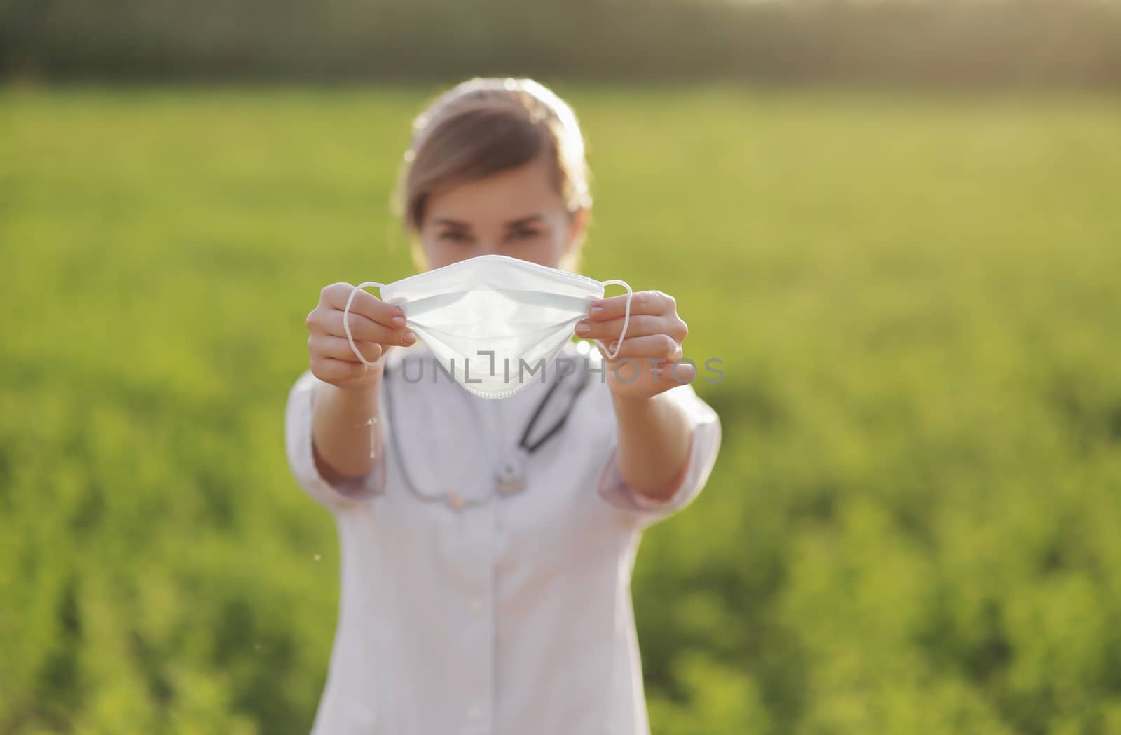 Young woman doctor or nurse showing medical face mask close up by selinsmo