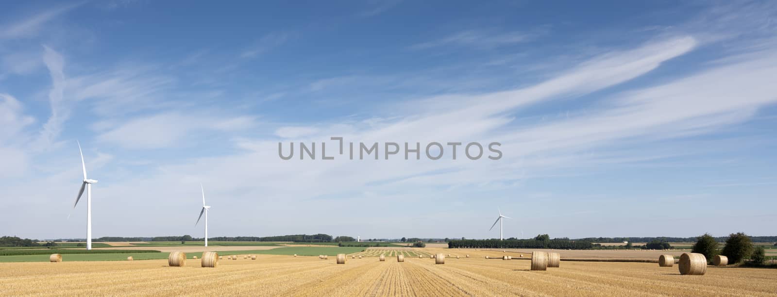 fields and wind turbines in french part nord pas de calais under blue sky in summer