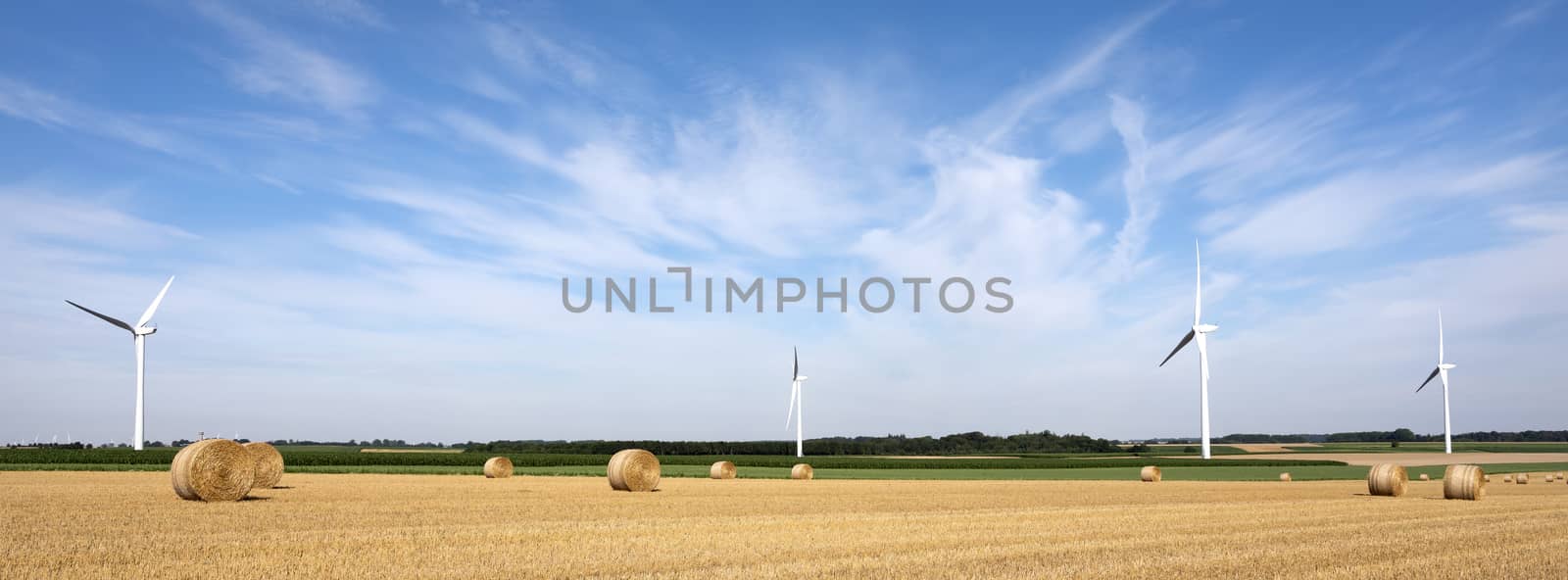 fields and wind turbine in the north of france under blue sky by ahavelaar