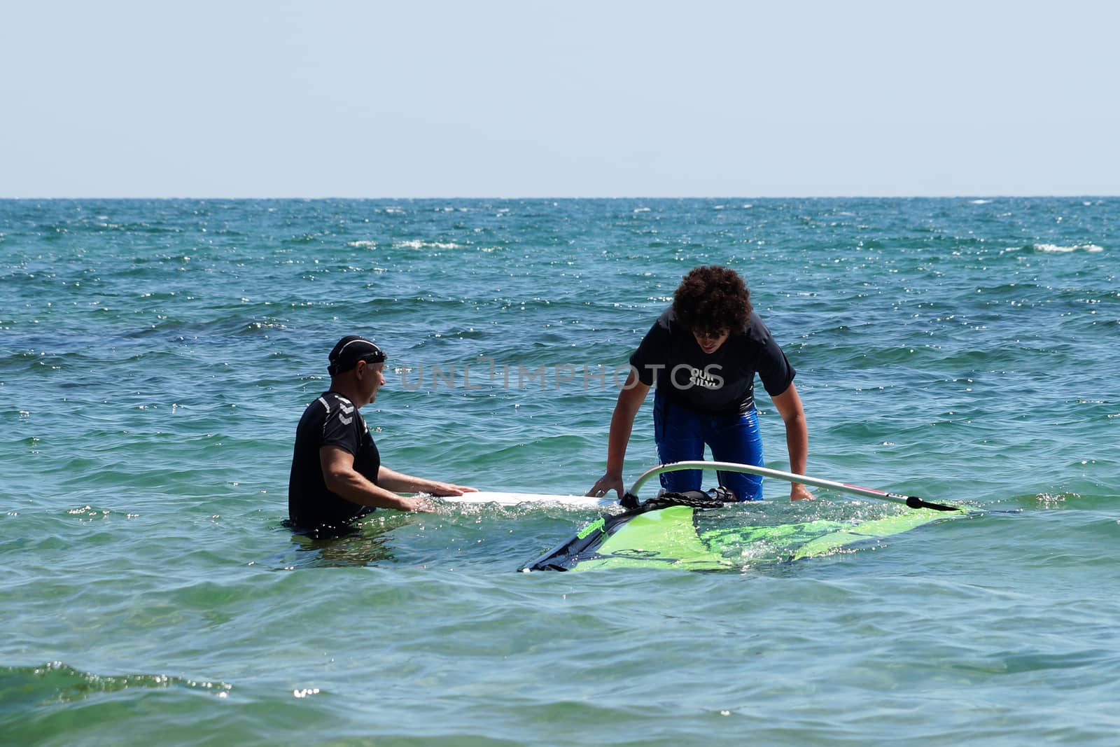 Varna, Bulgaria - July, 31,2020: two men learning to windsurf at sea