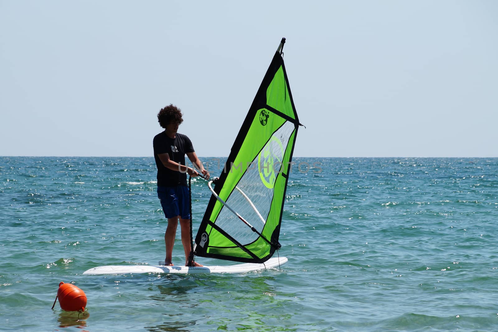 Varna, Bulgaria - July, 31,2020: young guy windsurfing in the sea