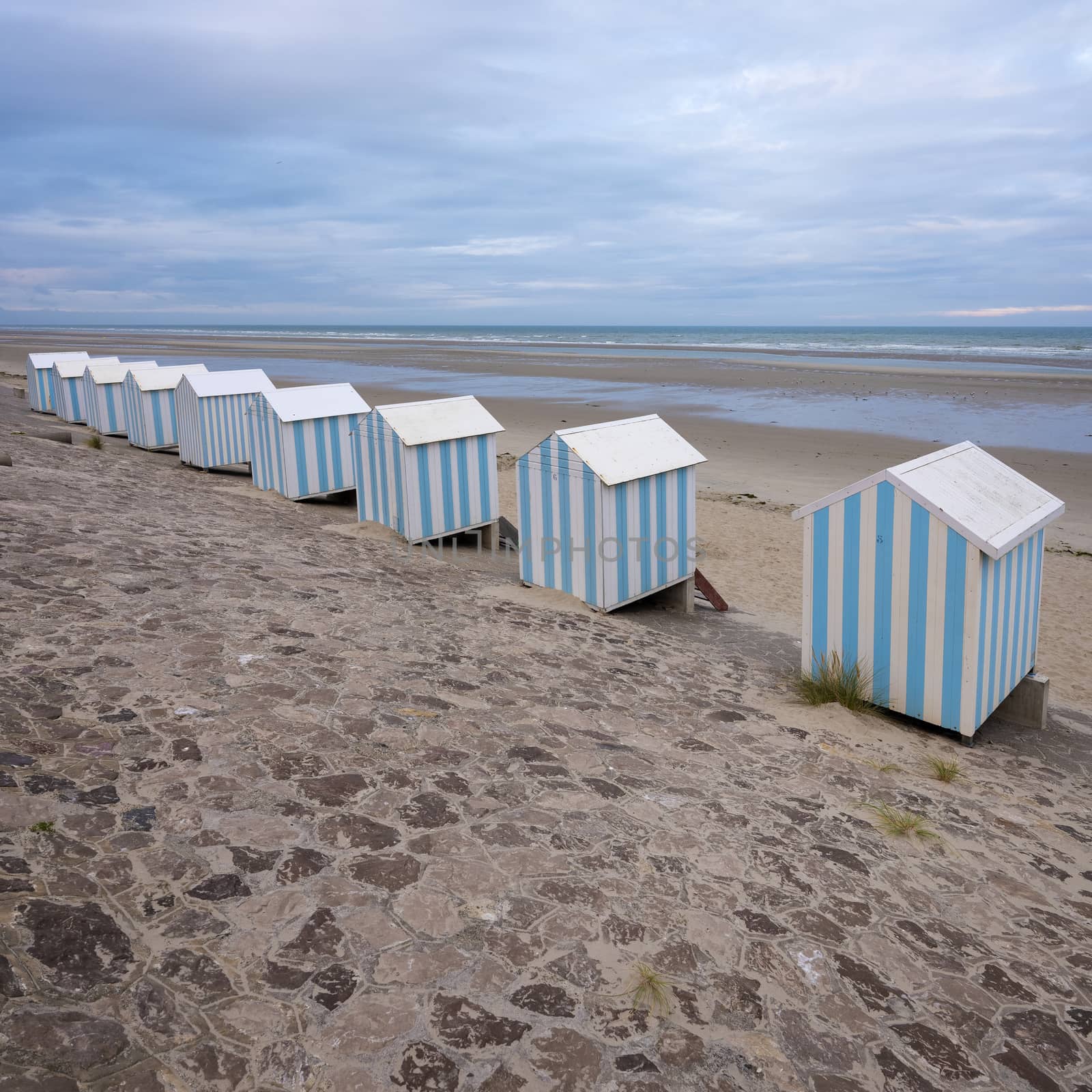 small striped beach huts in hardelot plage on the coast of normandy by ahavelaar