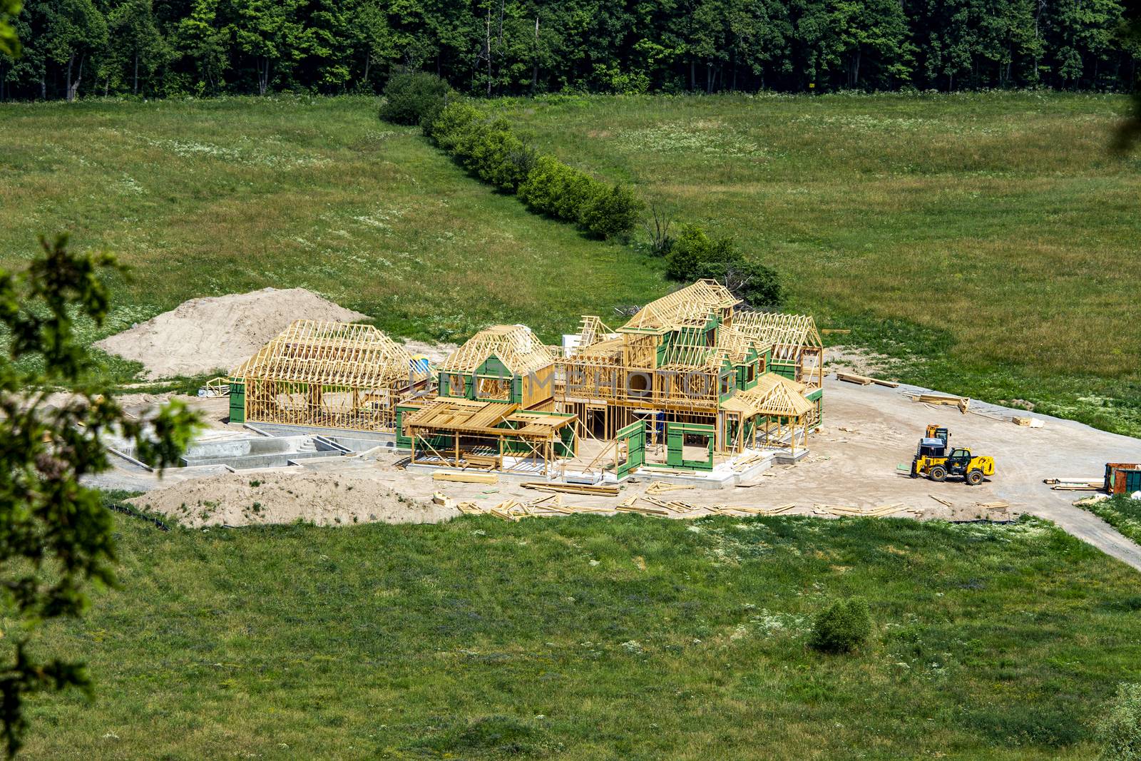 construction of a large wooden house on a green field