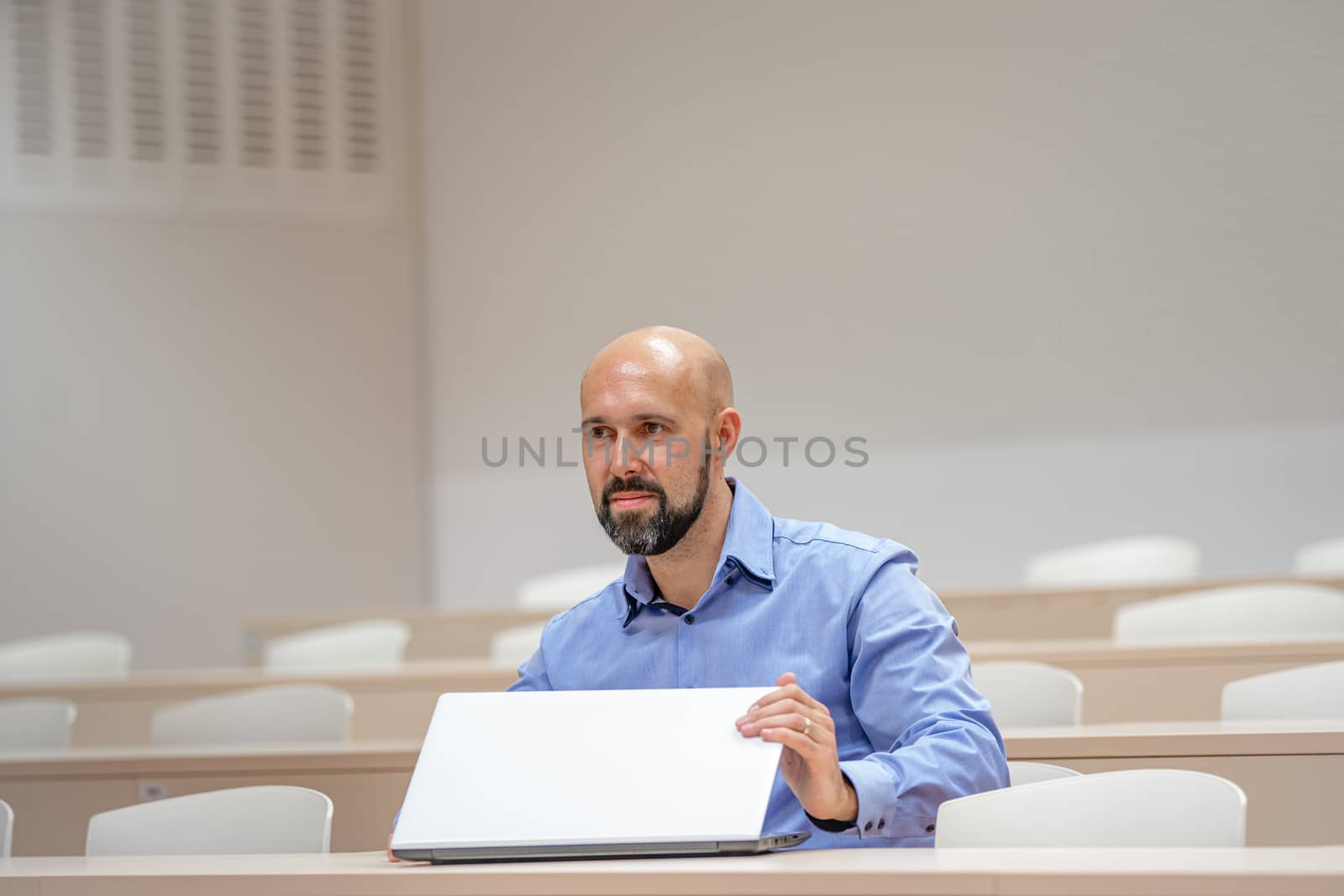 Young modern man on a university lecture working on a laptop by Edophoto