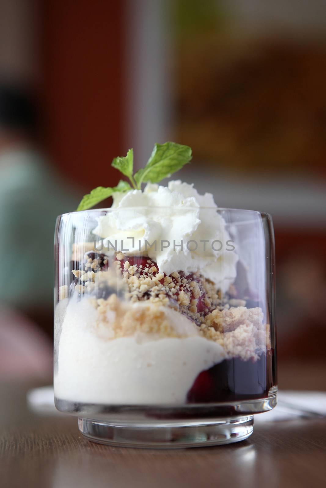 Vanilla ice cream with blue berry topping on wood background