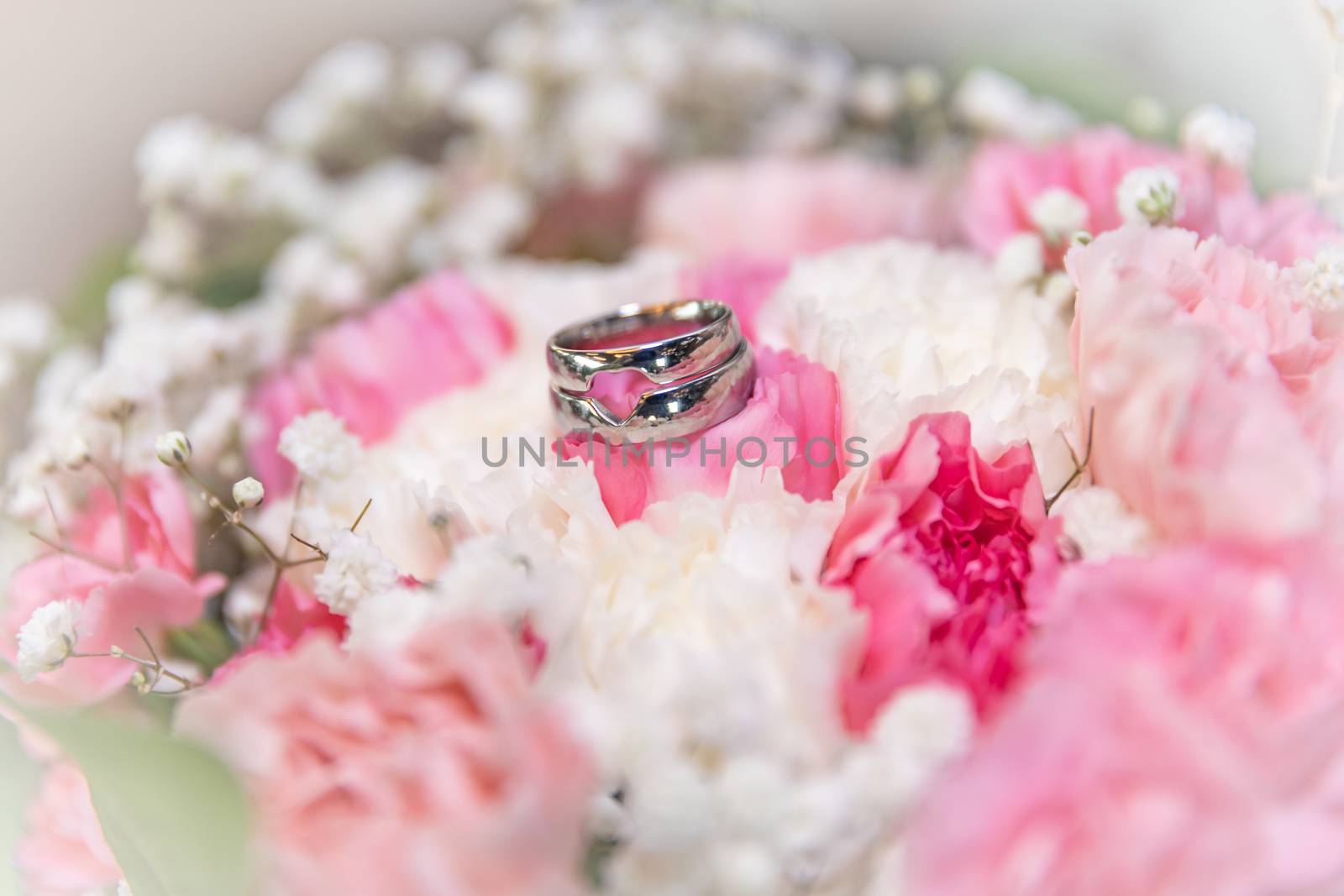 Flower decoration at the wedding. Wedding bouquet of bride and witness. Golden wedding rings on the flowers by Edophoto
