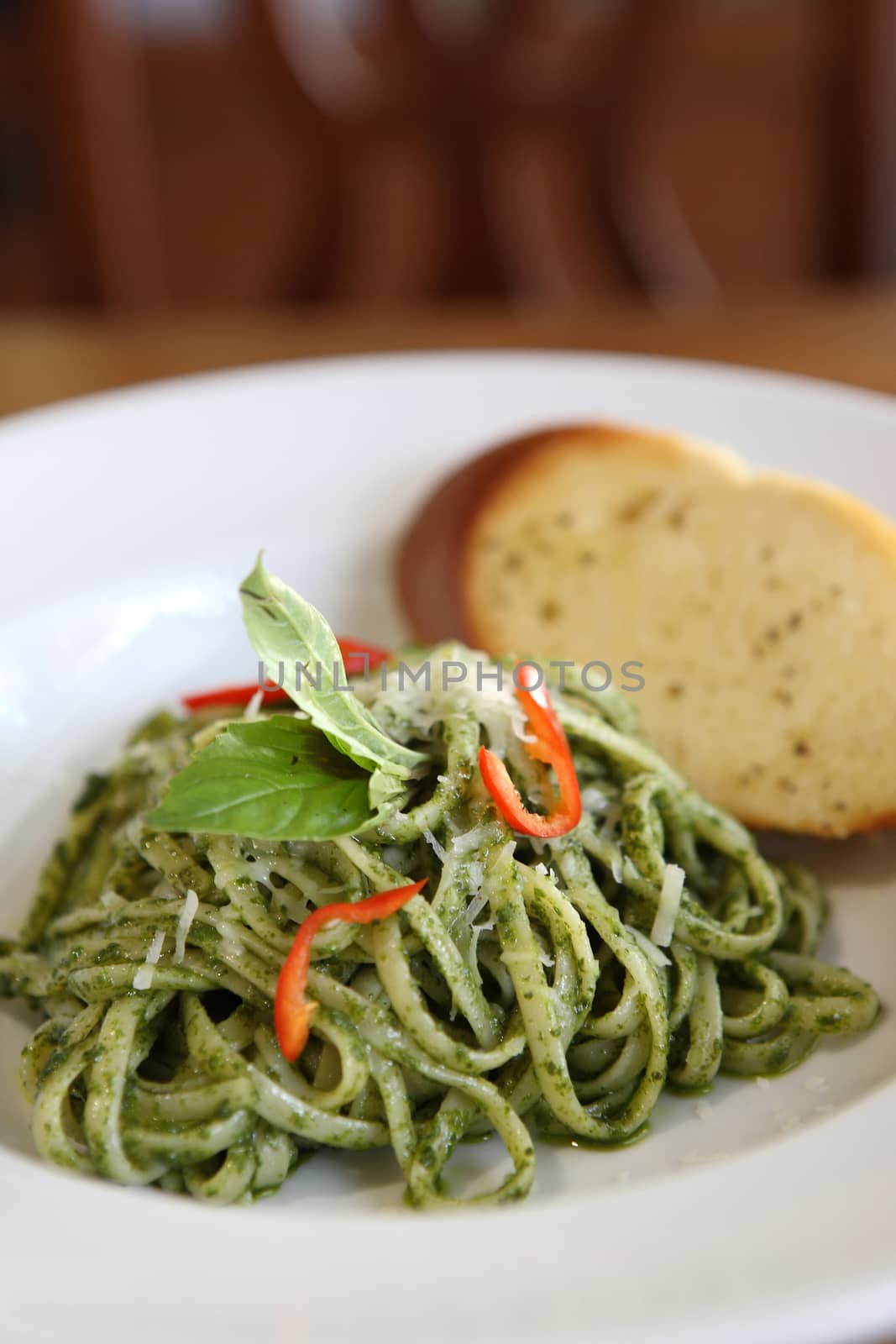 spaghetti with pesto sauce on wood background