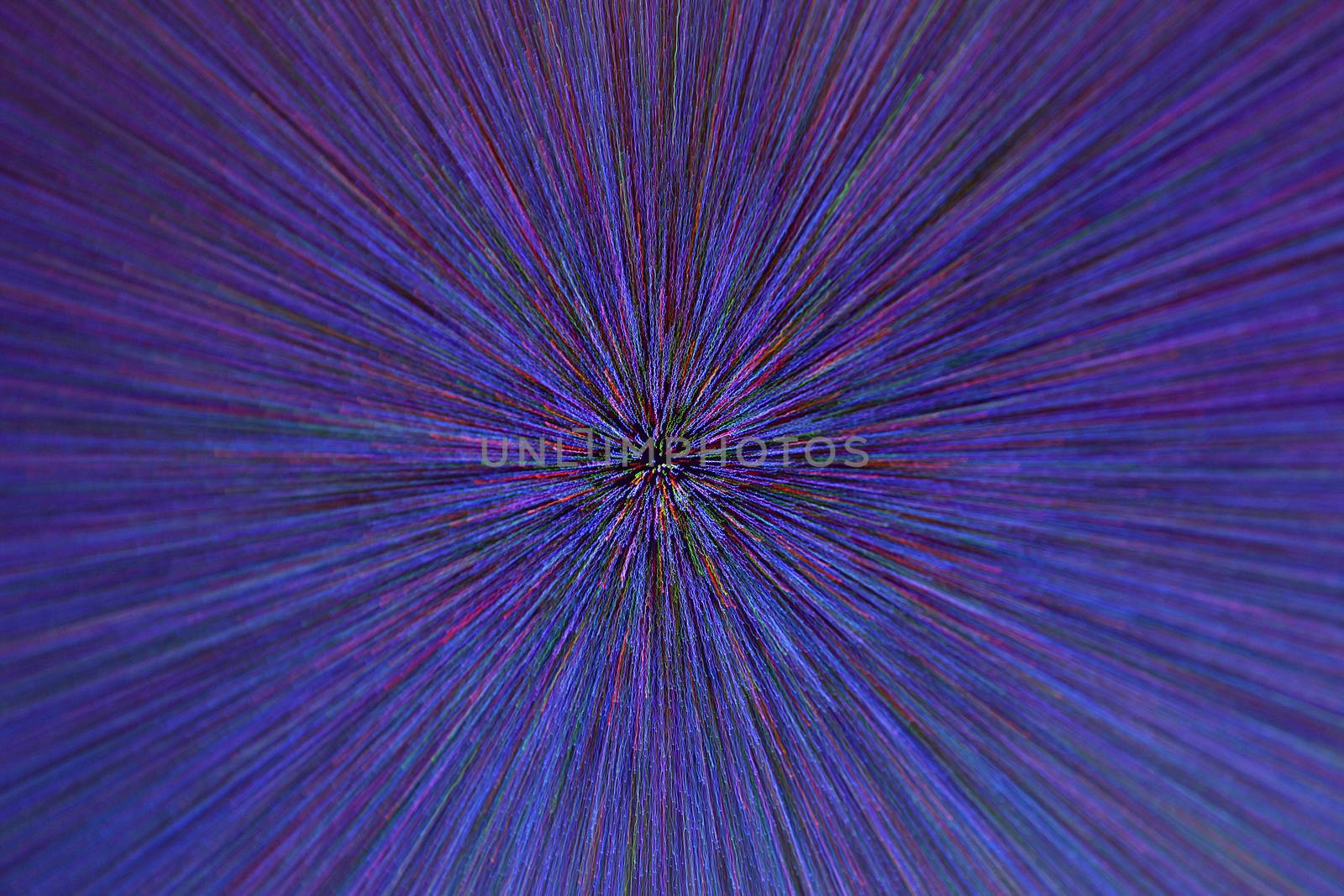 natural lens zoom explosion radial blurred red green blue dots on black background with selective focus.