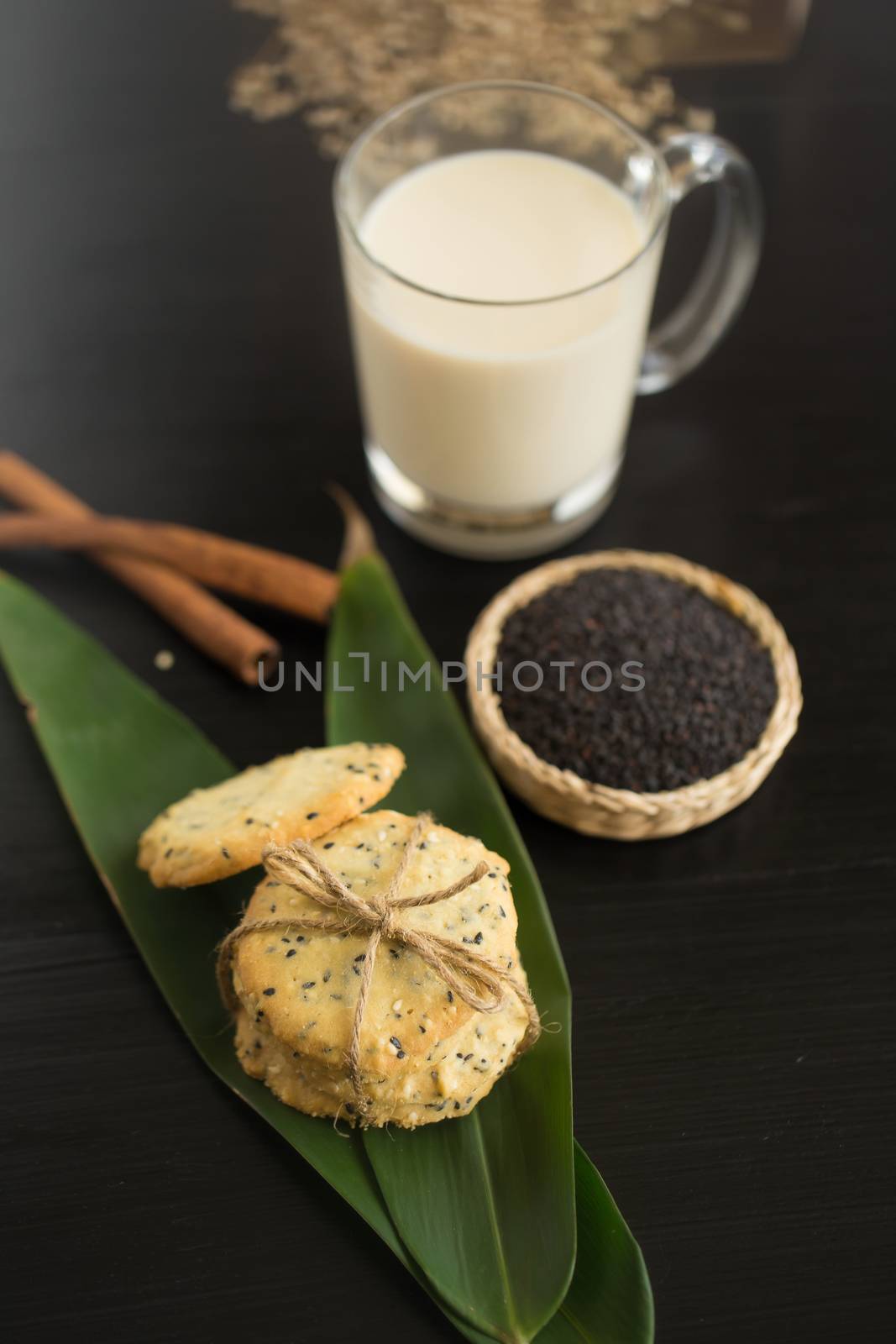 Sesame Cookies, sesame and milk on black wooden background by kaiskynet