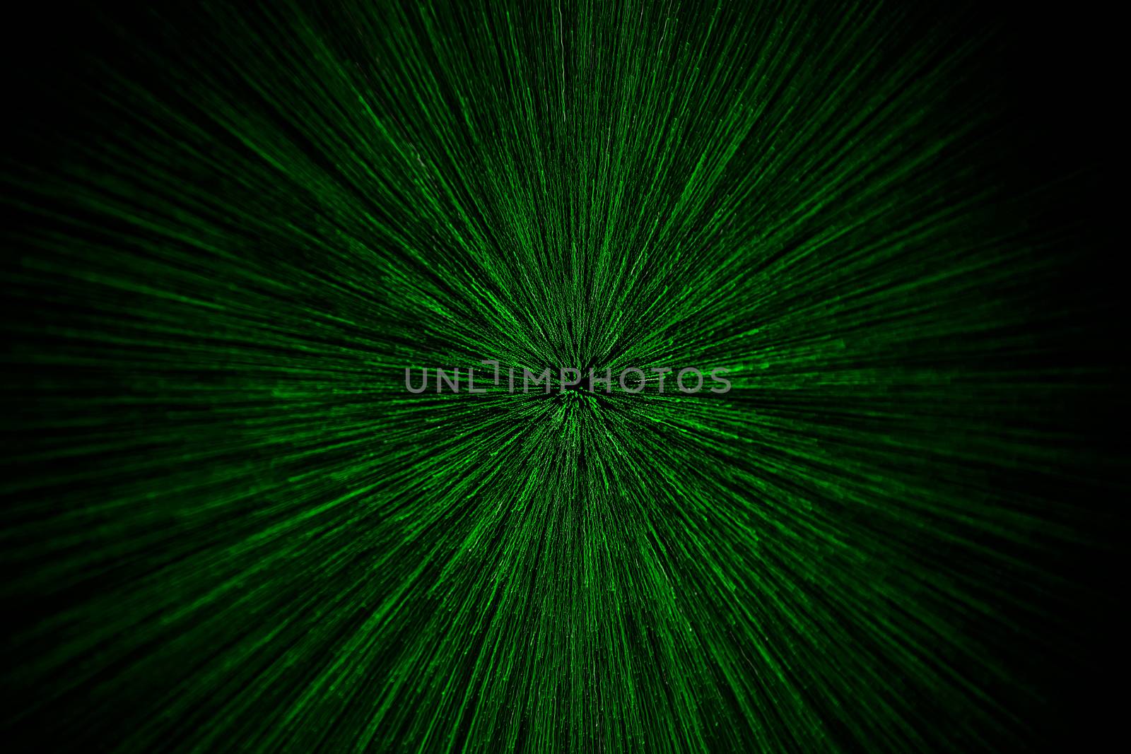 natural lens zoom explosion radial blurred green particles on black background with selective focus.