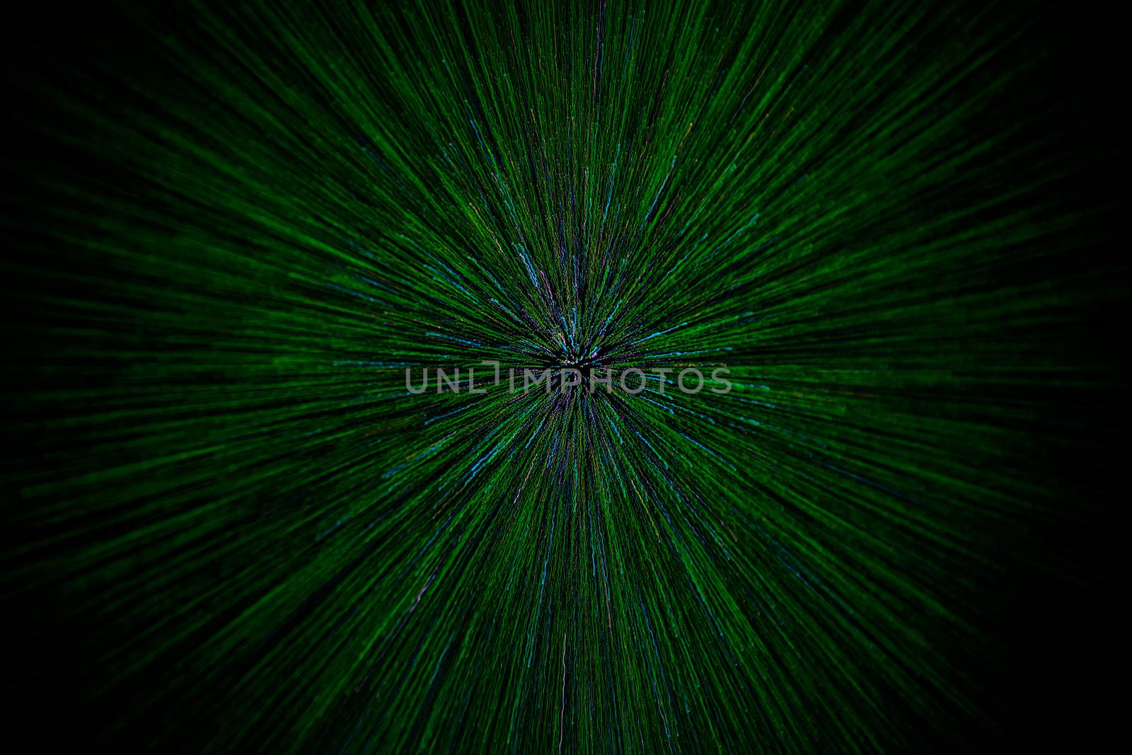 natural lens zoom explosion radial blurred green particles on black background with selective focus.
