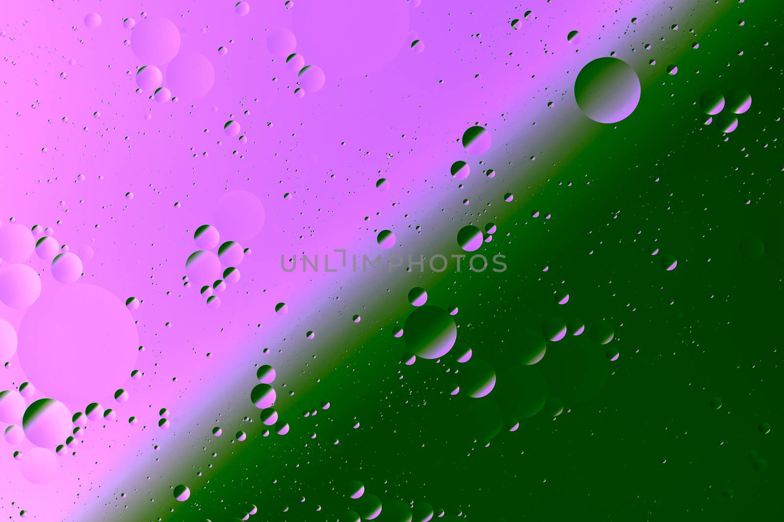Oil on water flat colorful duotone macro abstract background photographic image. Pink-green diagonal split line.