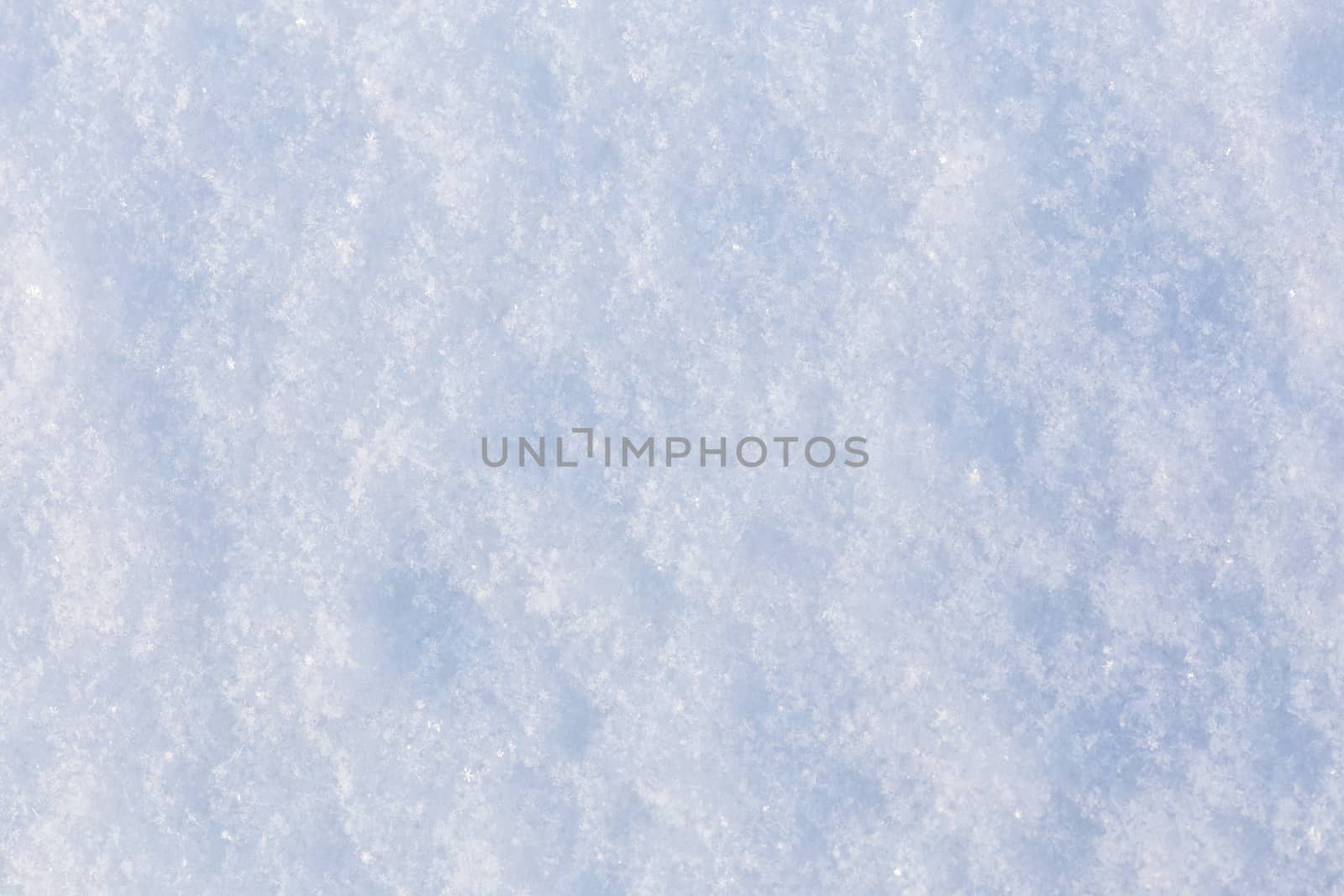 flat closeup texture of snow surface at daylight withs selective focus.