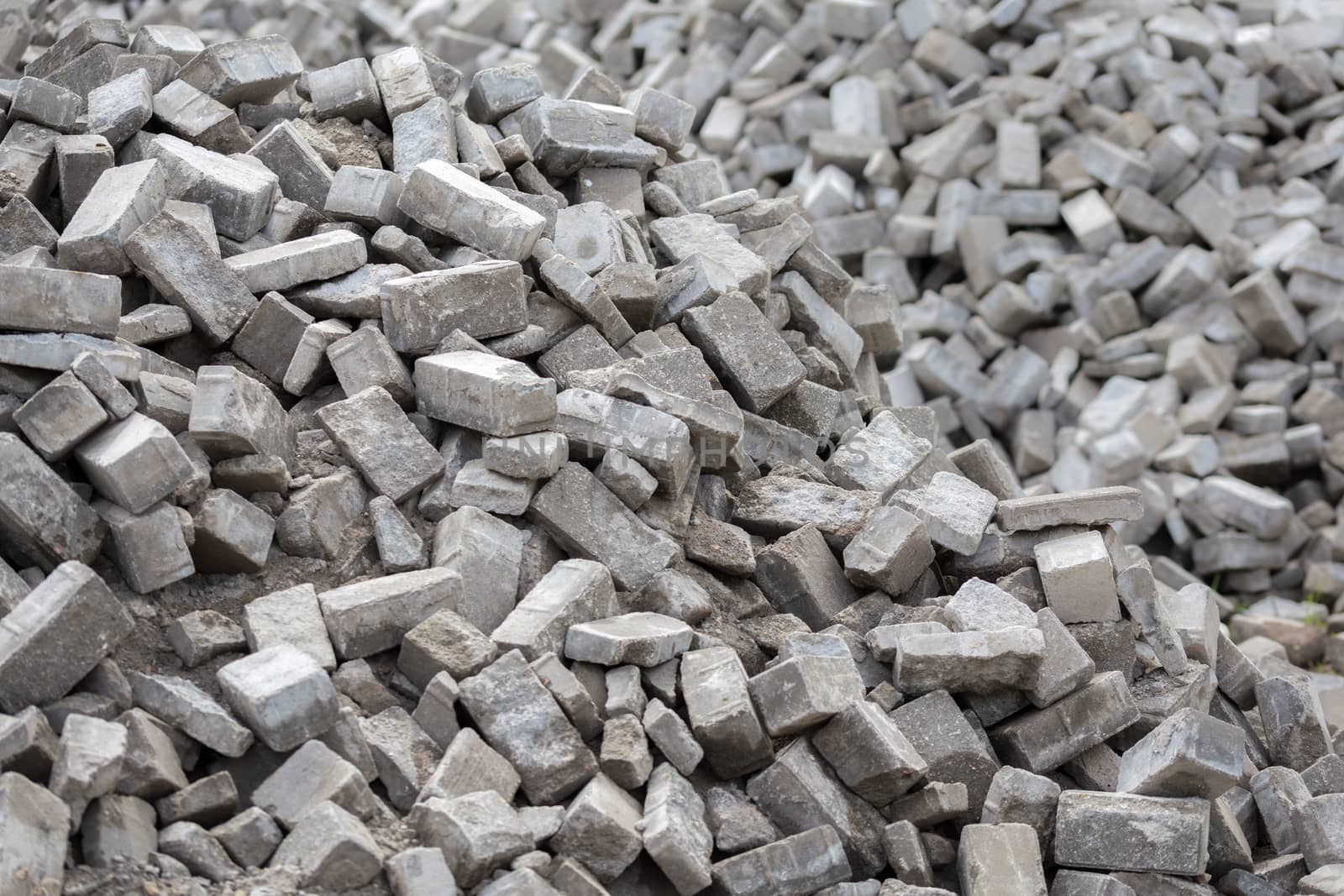 Pile of dismounted gray modern urban pavement bricks with selective focus. Result of russian government corruption in city infrastructure renovation.