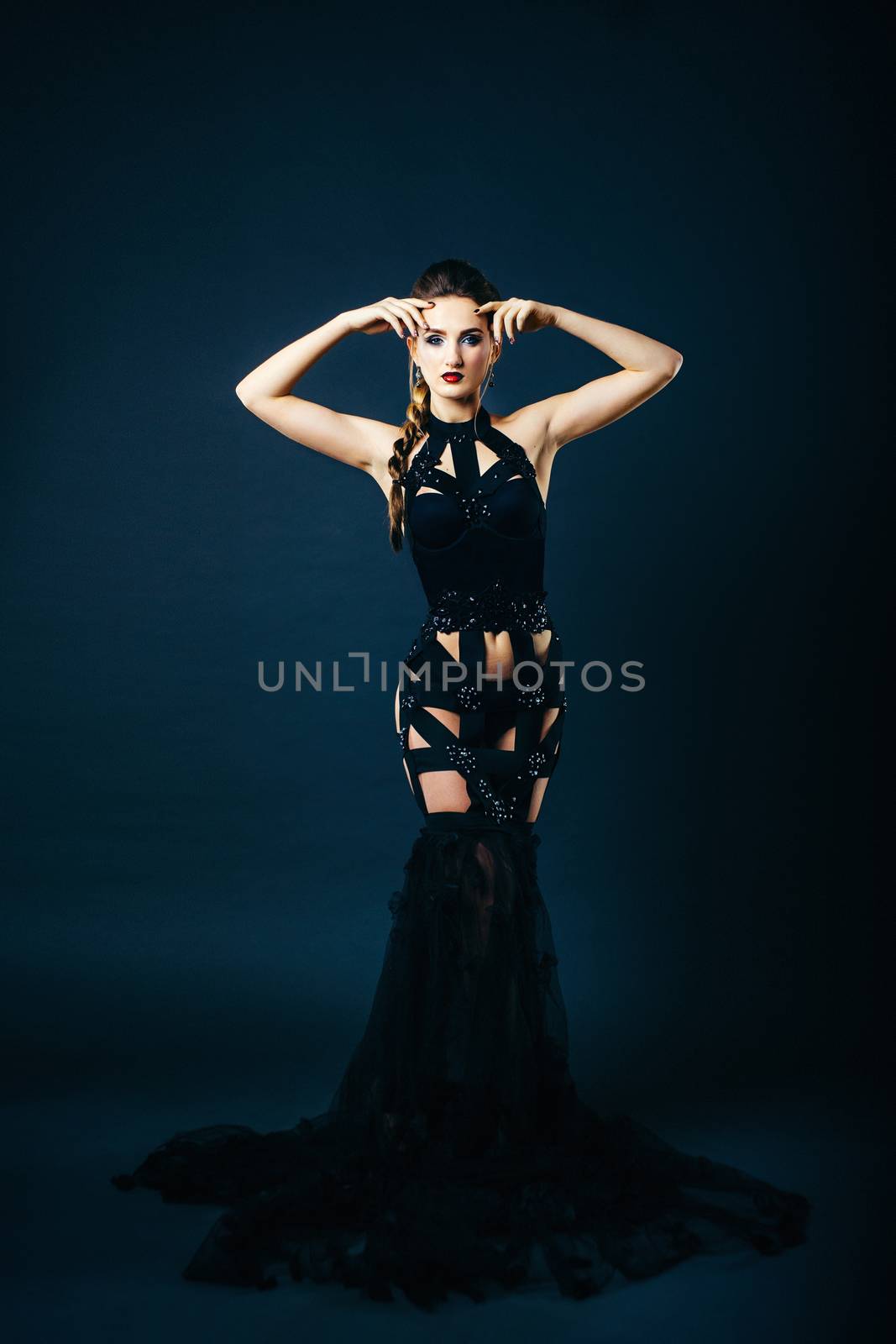 white girl modell on a dark background in a dress made of cut st by Andreua