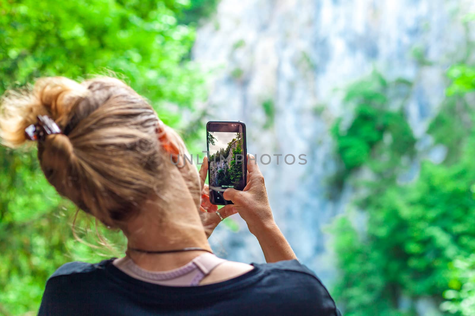 nature photography with the help of a smart phone by a young tourist on a trip.