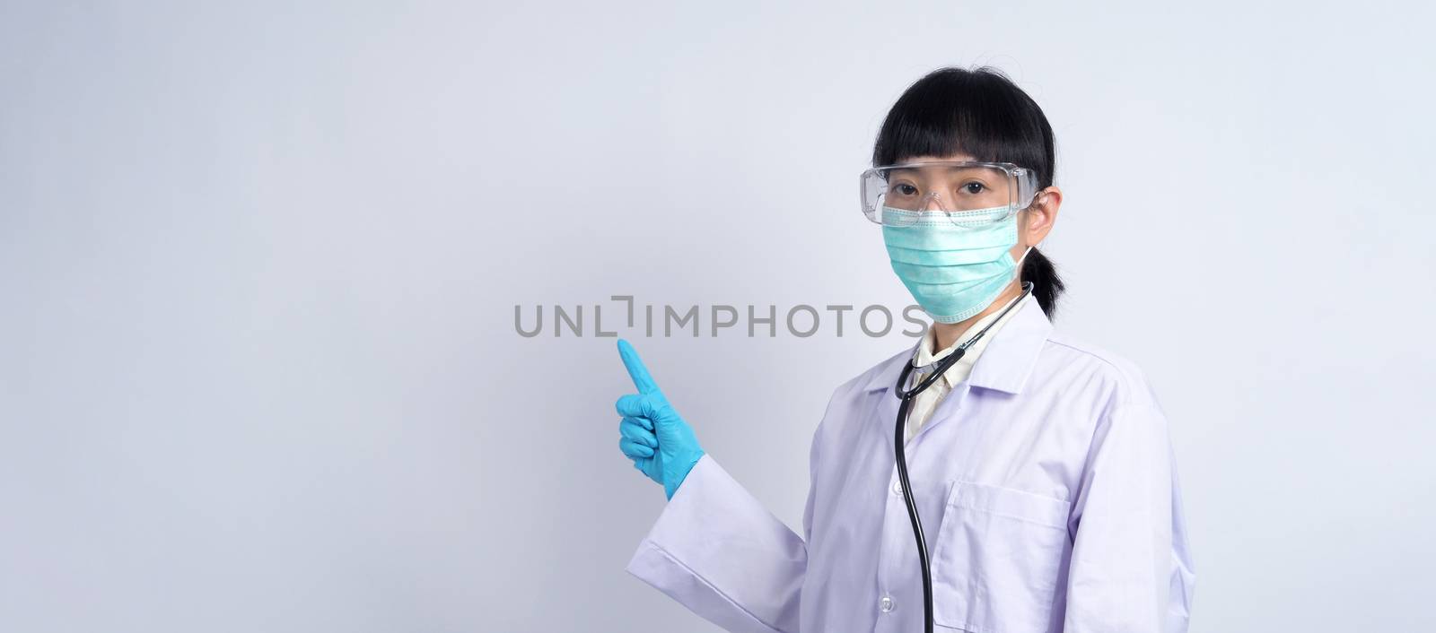 Asian woman doctor pointing finger out to copy space by gnepphoto