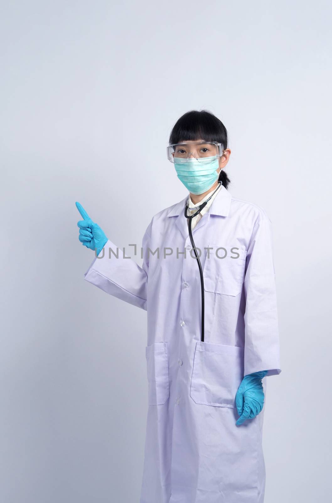 Asian woman doctor pointing finger out to copy space by gnepphoto