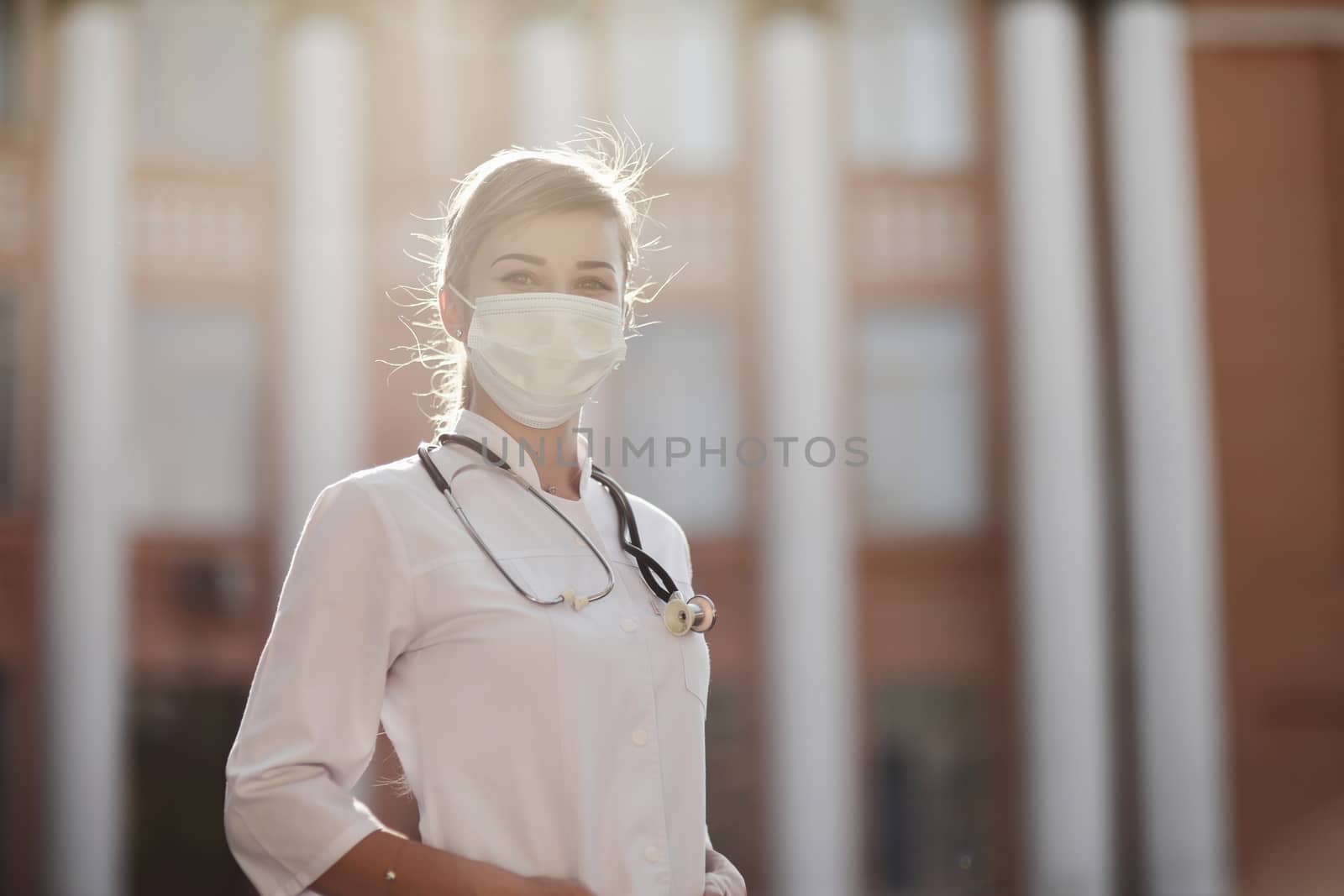 Confident female doctor or nurse wearing a face protective mask. Safety measures against the coronavirus. Prevention Covid-19 healthcare concept. Stethoscope over the neck. Woman, girl.