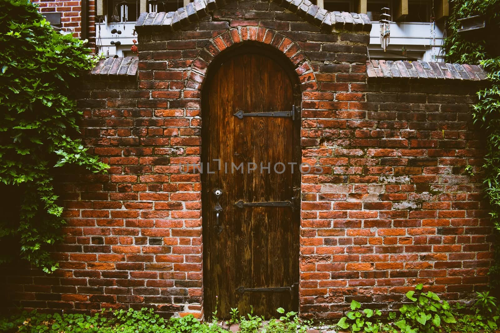 An Old Wooden Door in a Worn Brick Facade