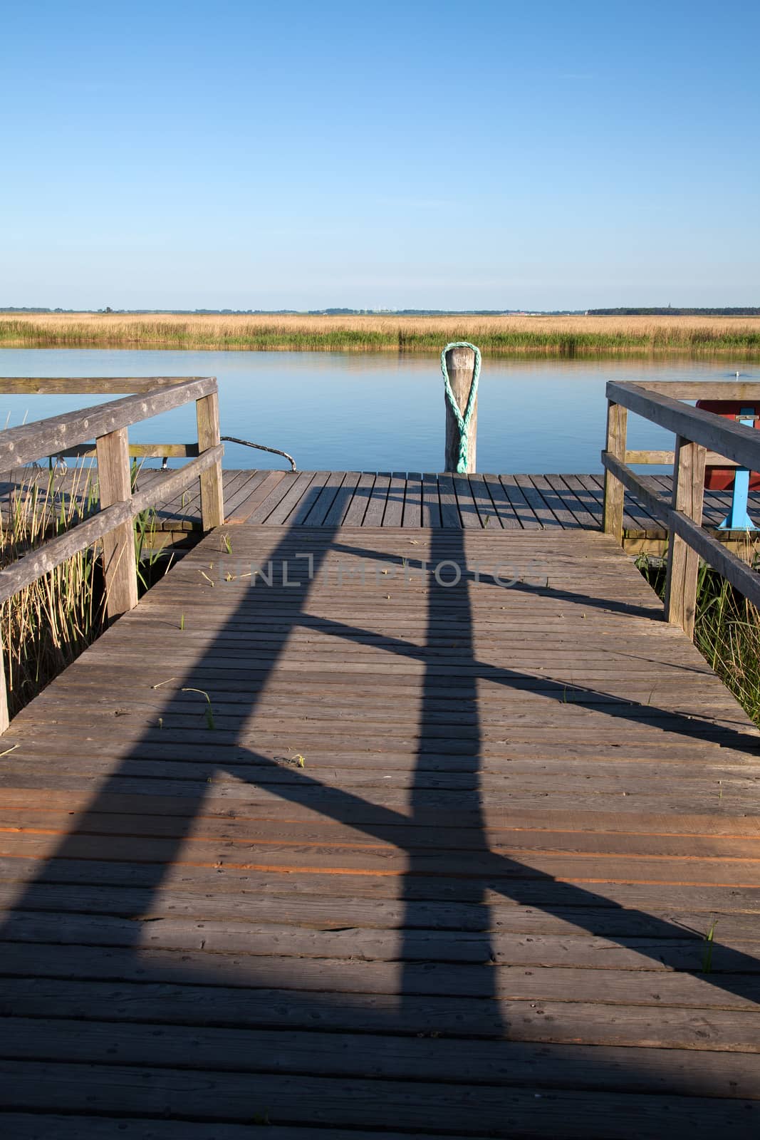 Old wooden pier with railing and wooden pile at the Baltic Sea