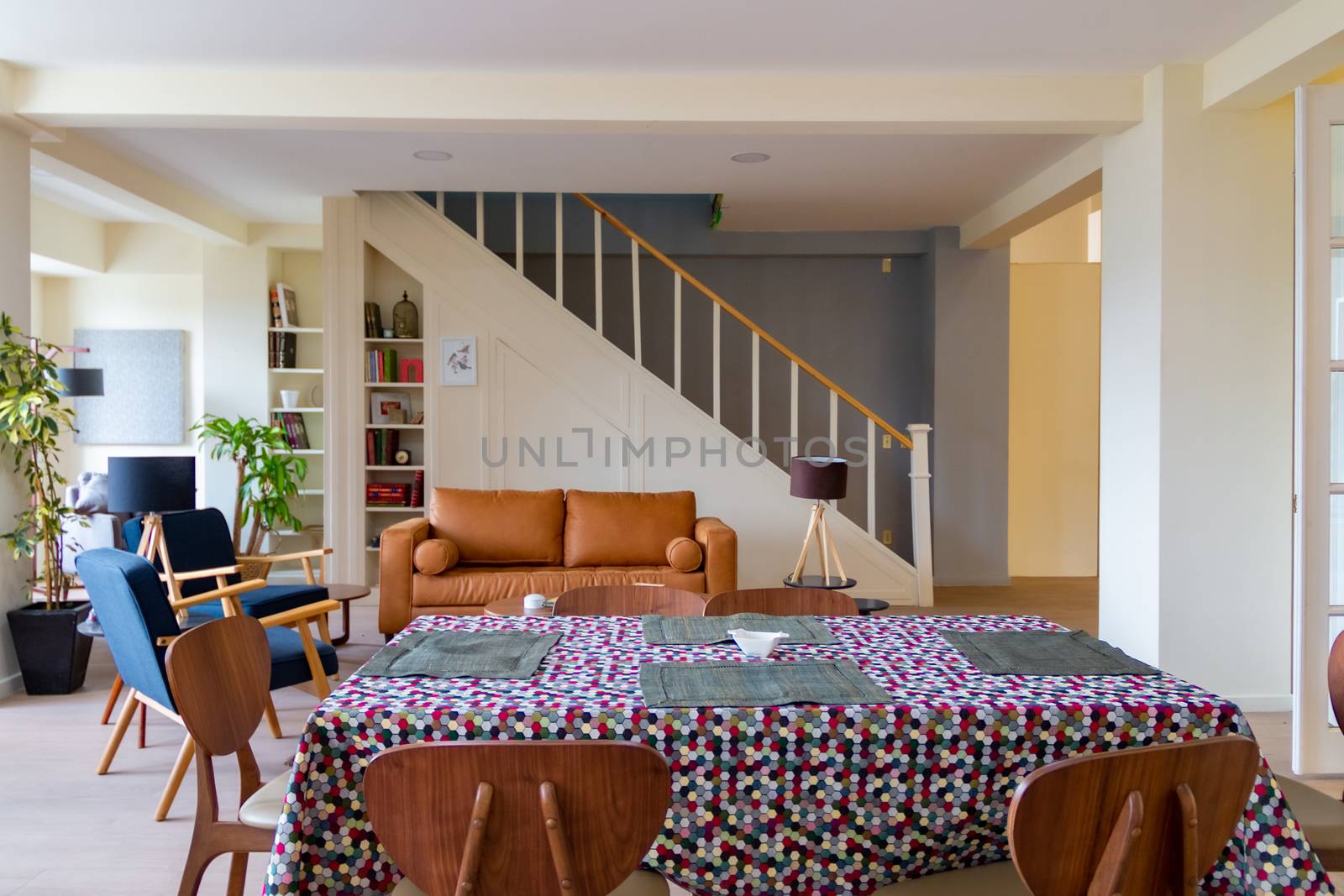 Modern room with brown armchair and stairs in the background. flowery dining room