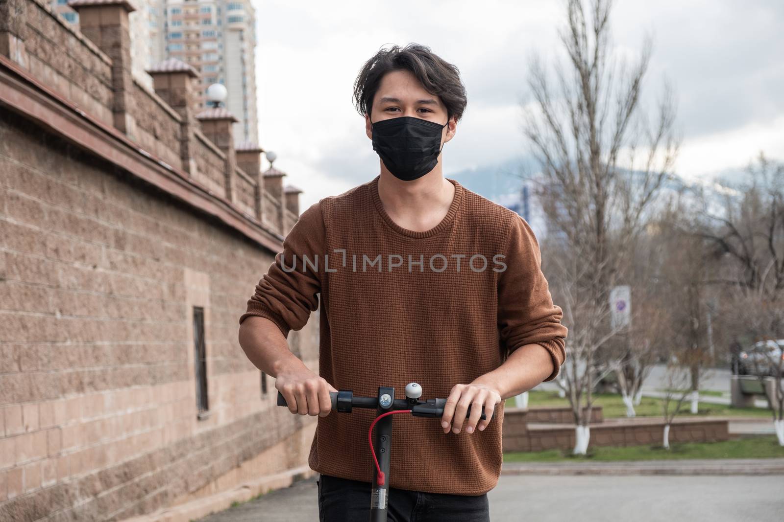 Young man riding a scooter in the city