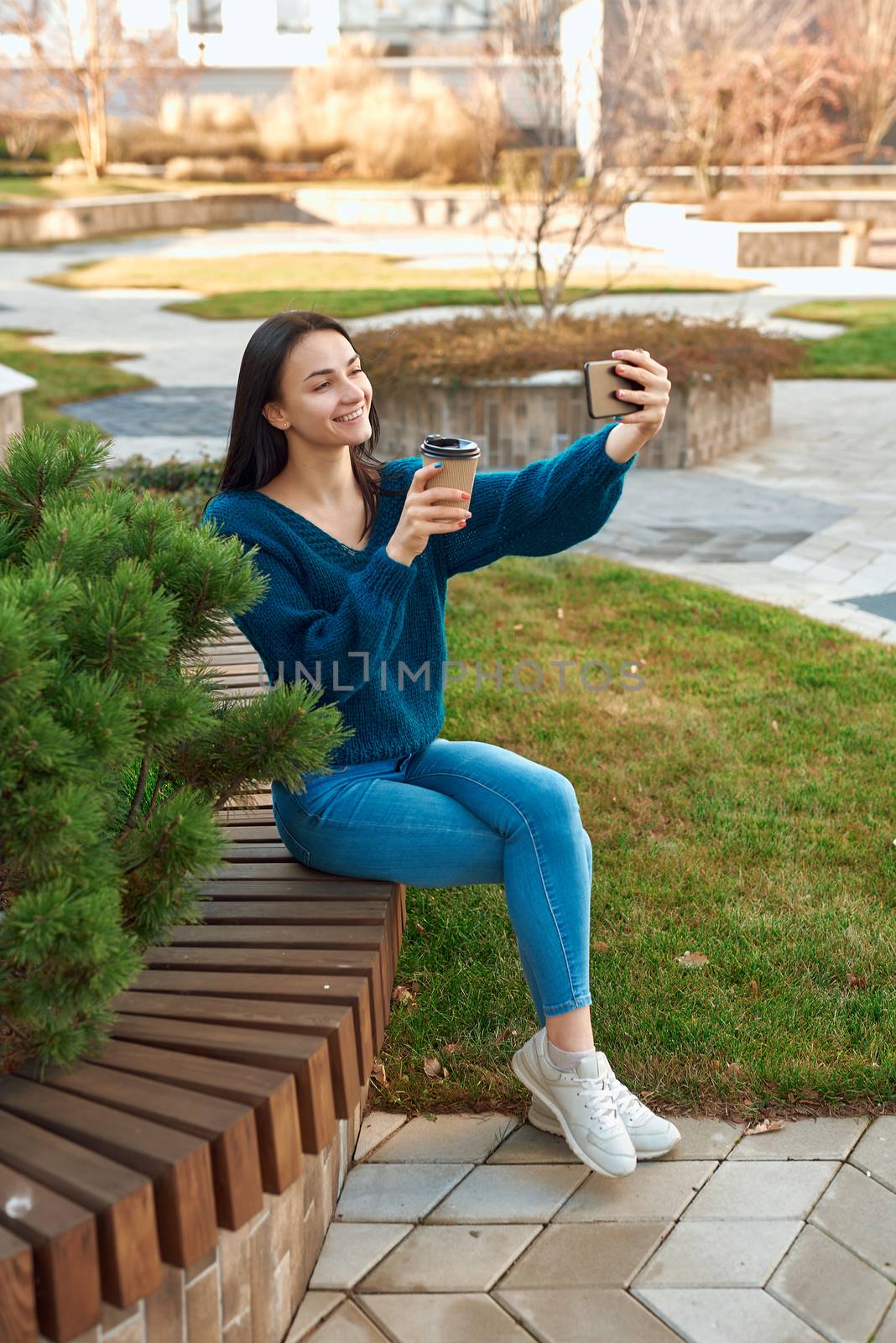 Charming lady posing for selfie on a bench in beautiful square by monakoartstudio