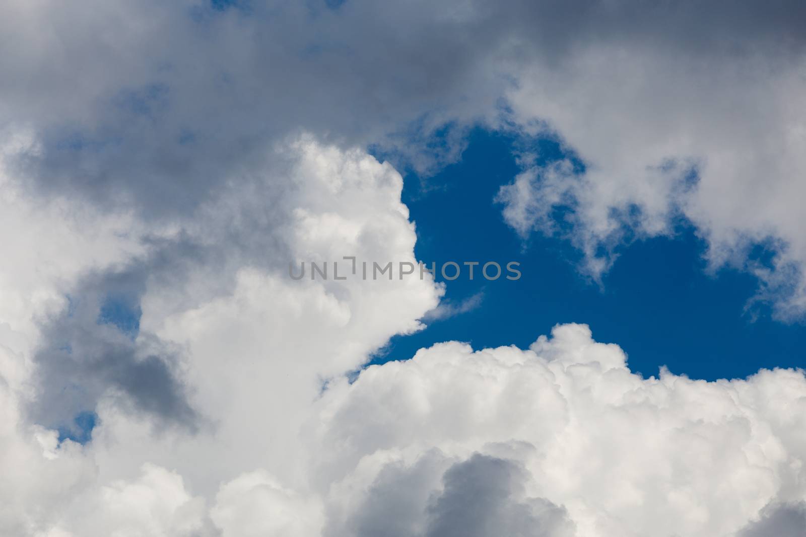 Regular spring clouds on blue sky at daylight in continental europe. Close shot wit telephoto lens