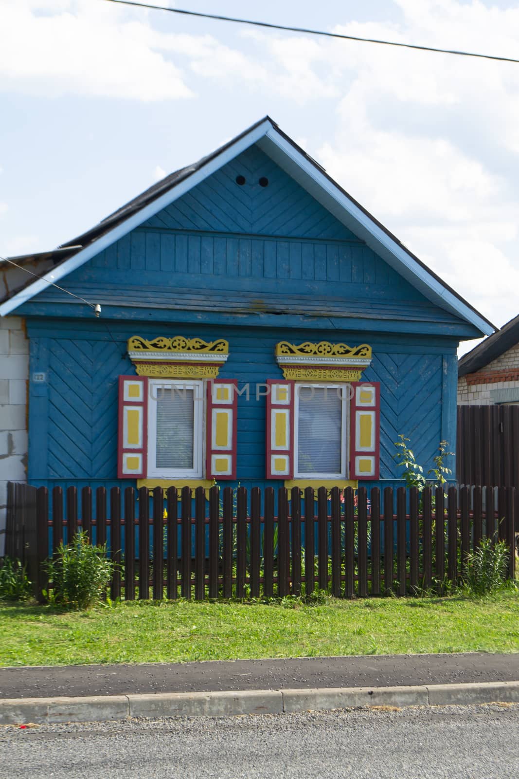 Traditional village in Belarus. Wooden folk architecture, facade with colorful windows, vertical image