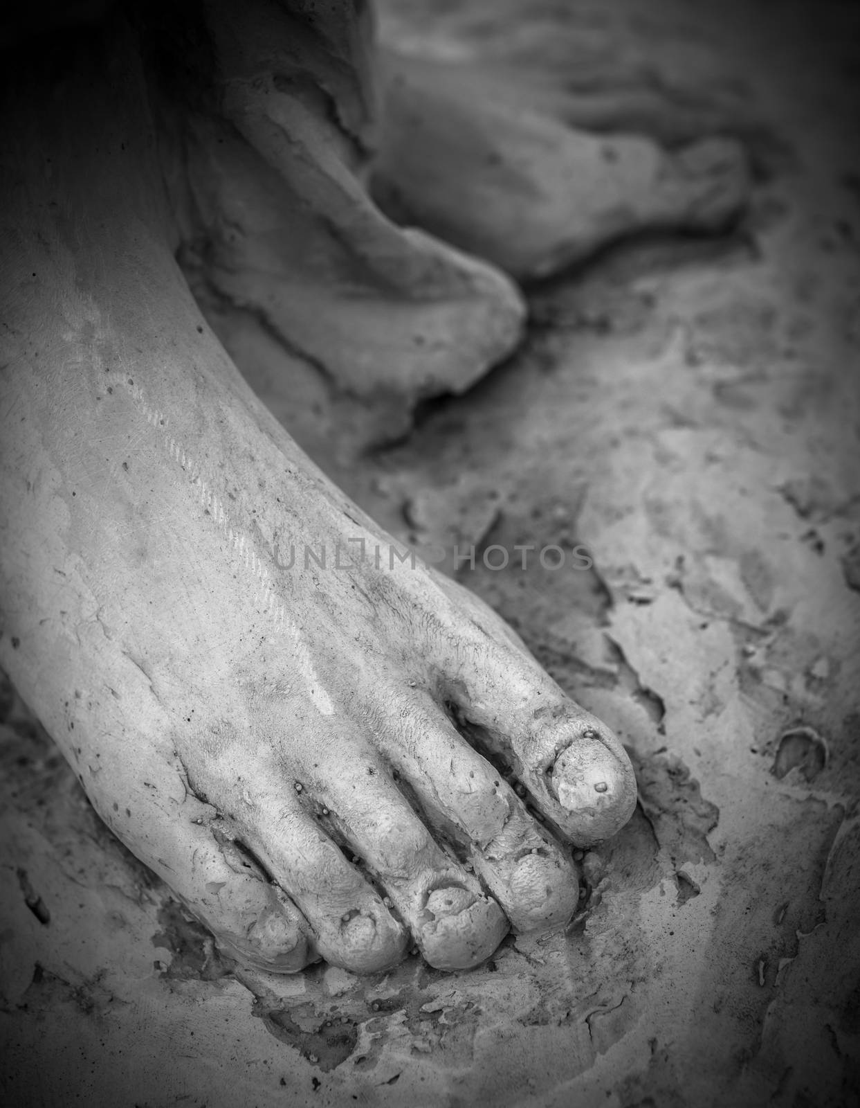 Detail of a marble statue, depicting the foot of the suffering Christ